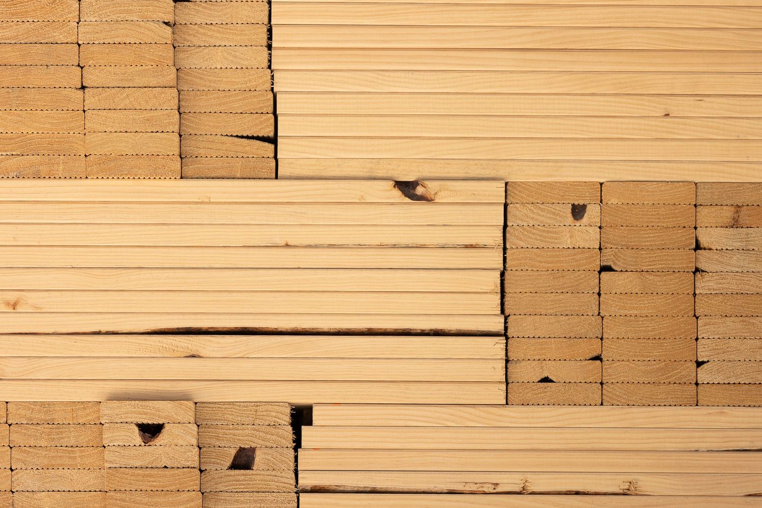 Close-up texture of stacked wooden timber planks showing natural grain patterns and edges.