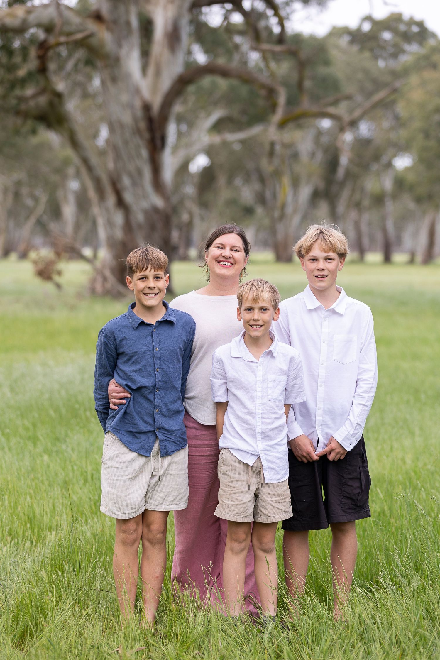 Group photo of children in coordinated outfits standing in tall grass.