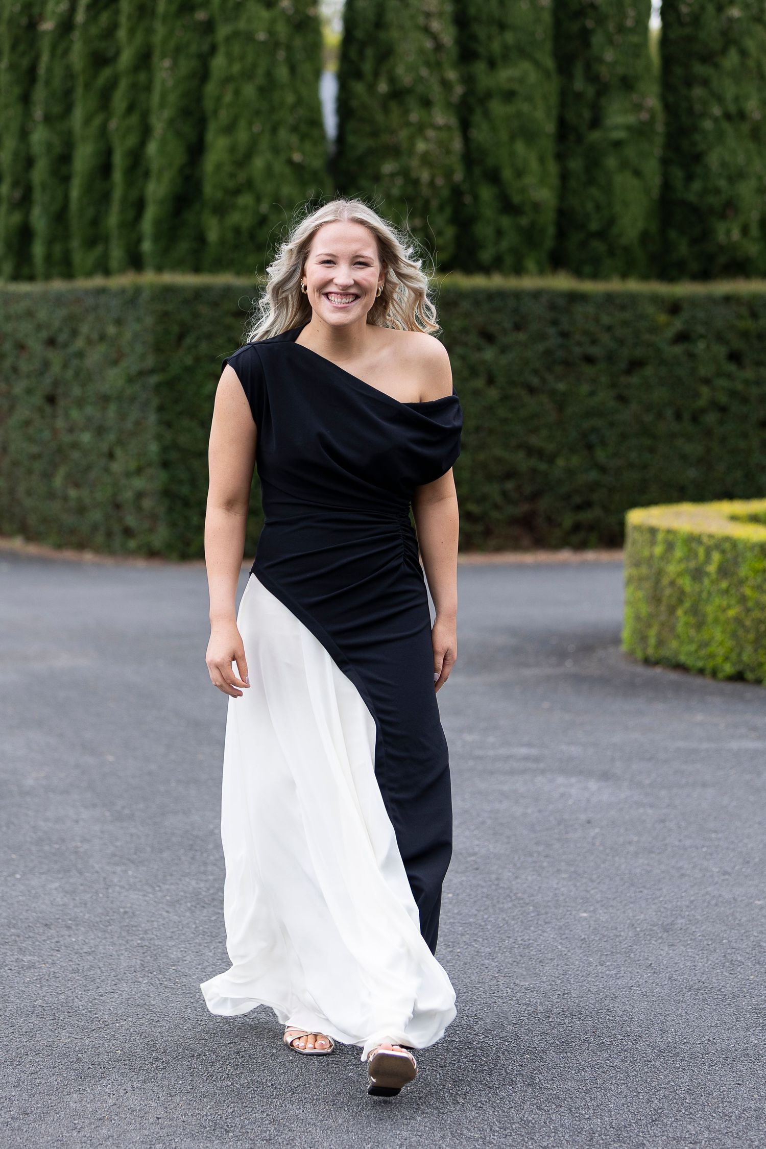 Multiple shots of someone in a dramatic black and white dress posing against a garden backdrop.