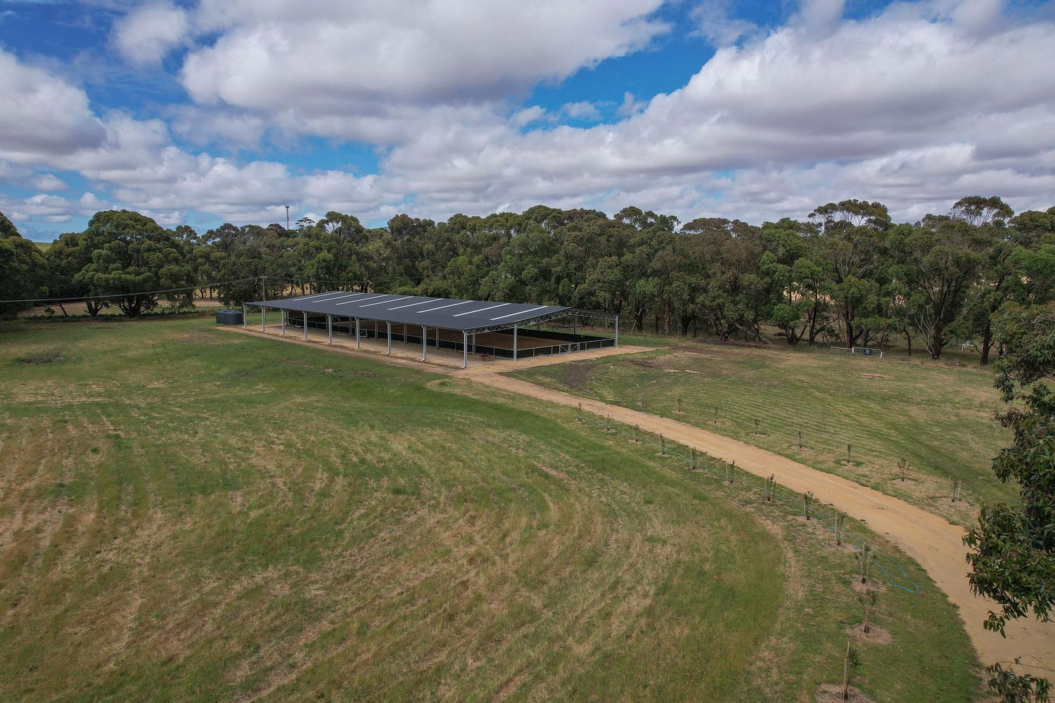 Wide landscape view of equestrian facility surrounded by Australian countryside.