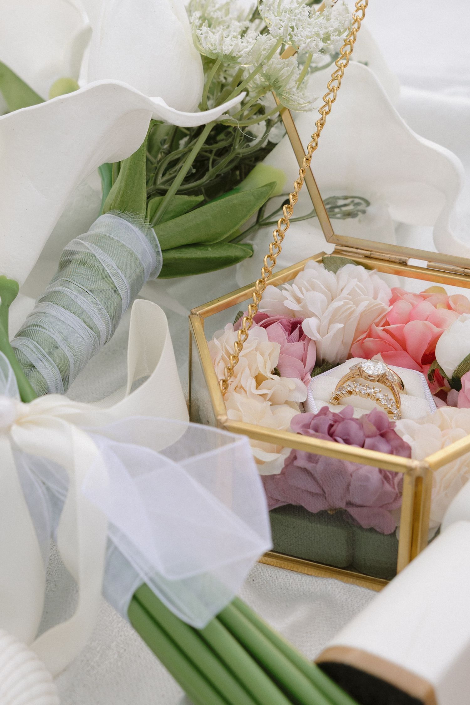 Tofino elopement details delicate floral arrangements in a gold geometric box with white and pink blooms