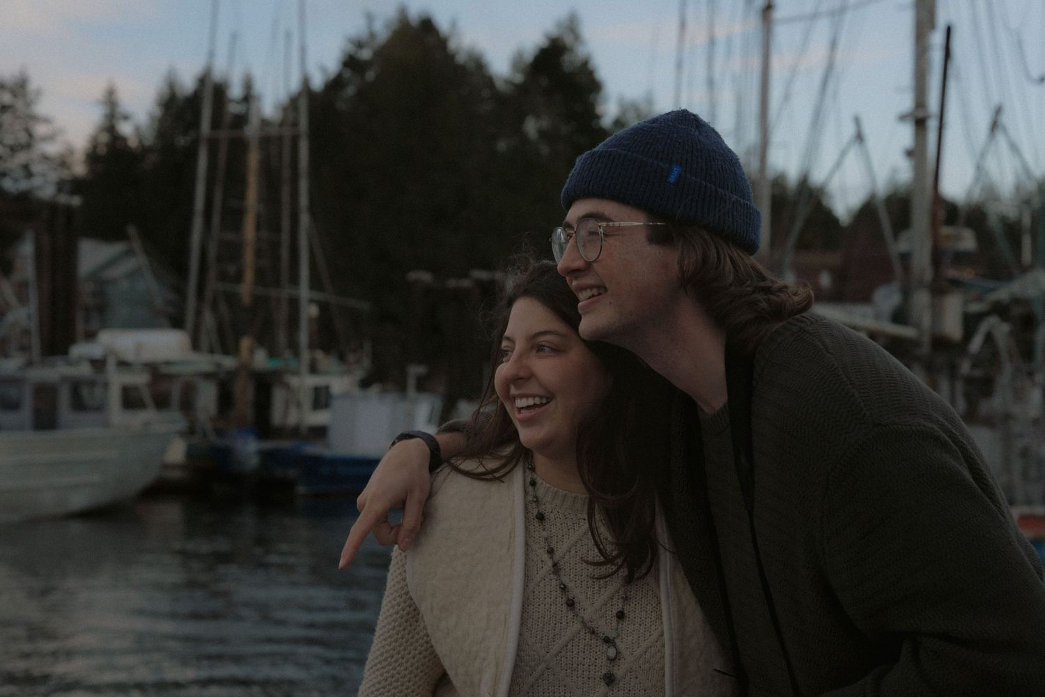 A casual interaction between people on a boat dock at twilight.