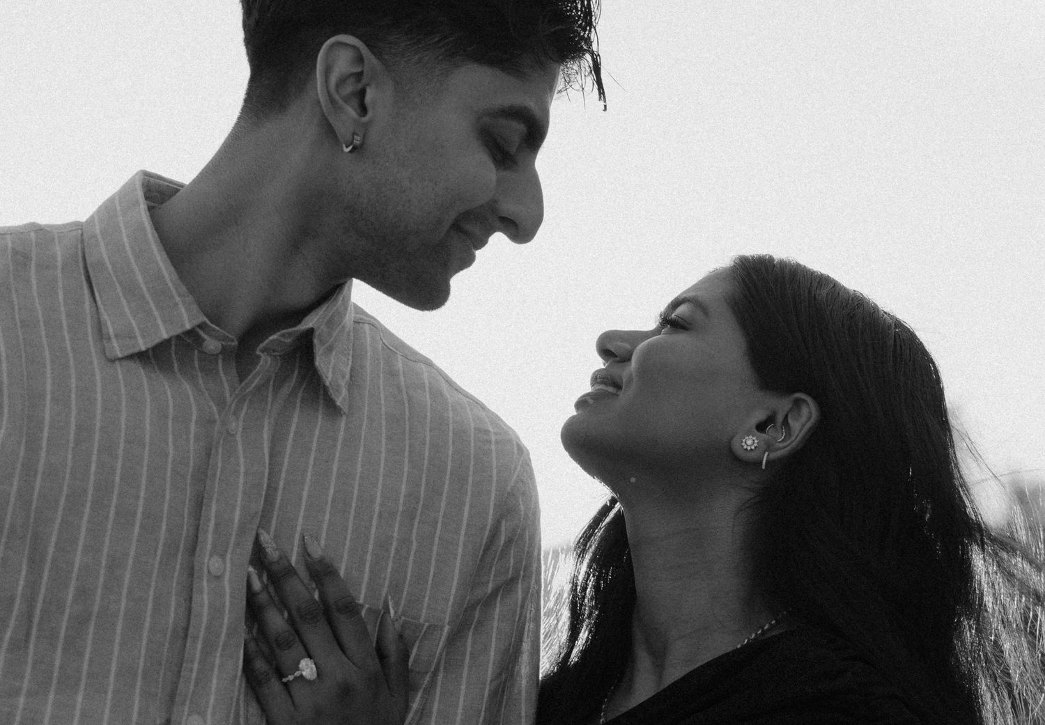 Black and white photo of a young couple sharing an intimate romantic moment, gazing at each other tenderly.