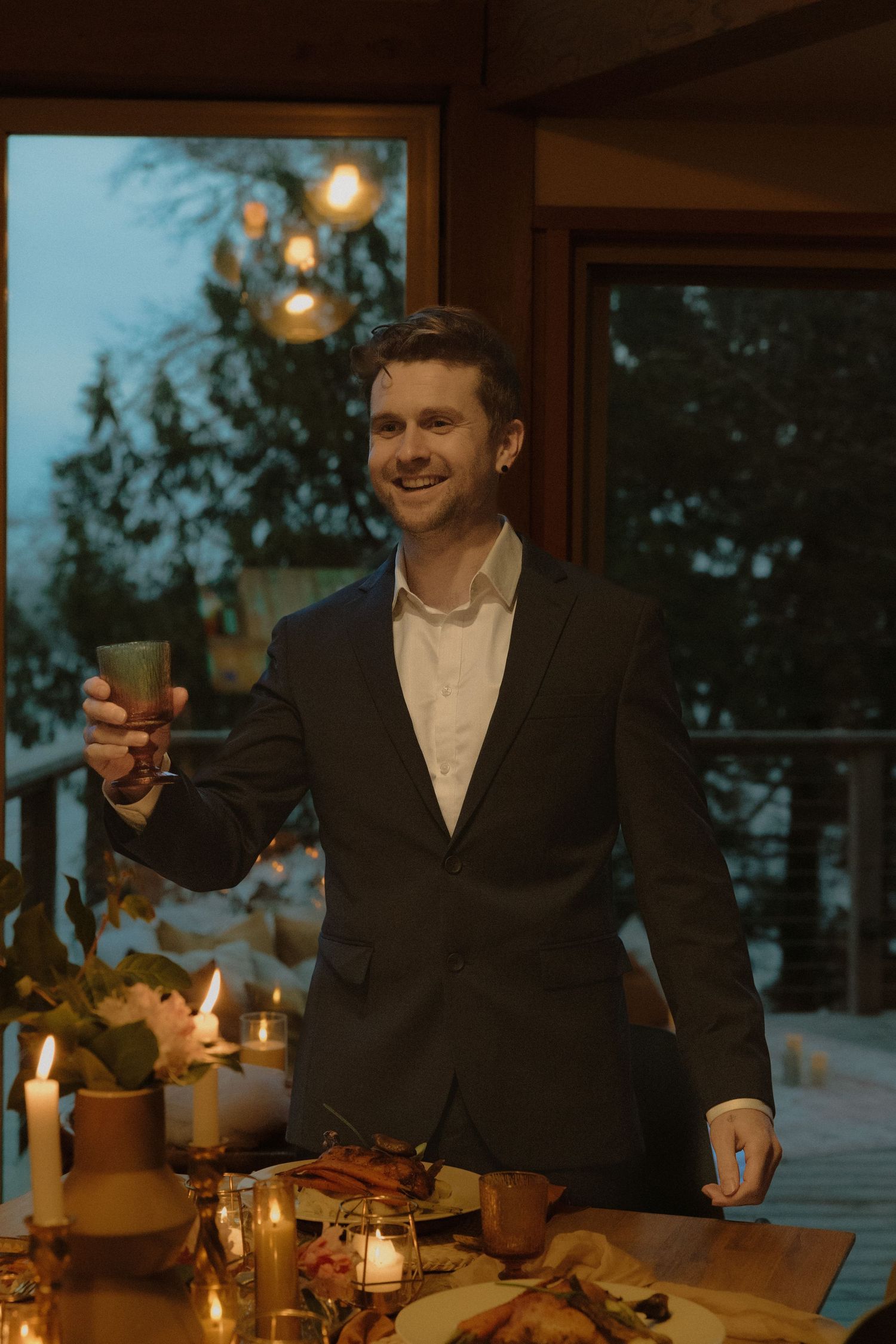 A formal dinner setup with someone raising a glass in celebration.