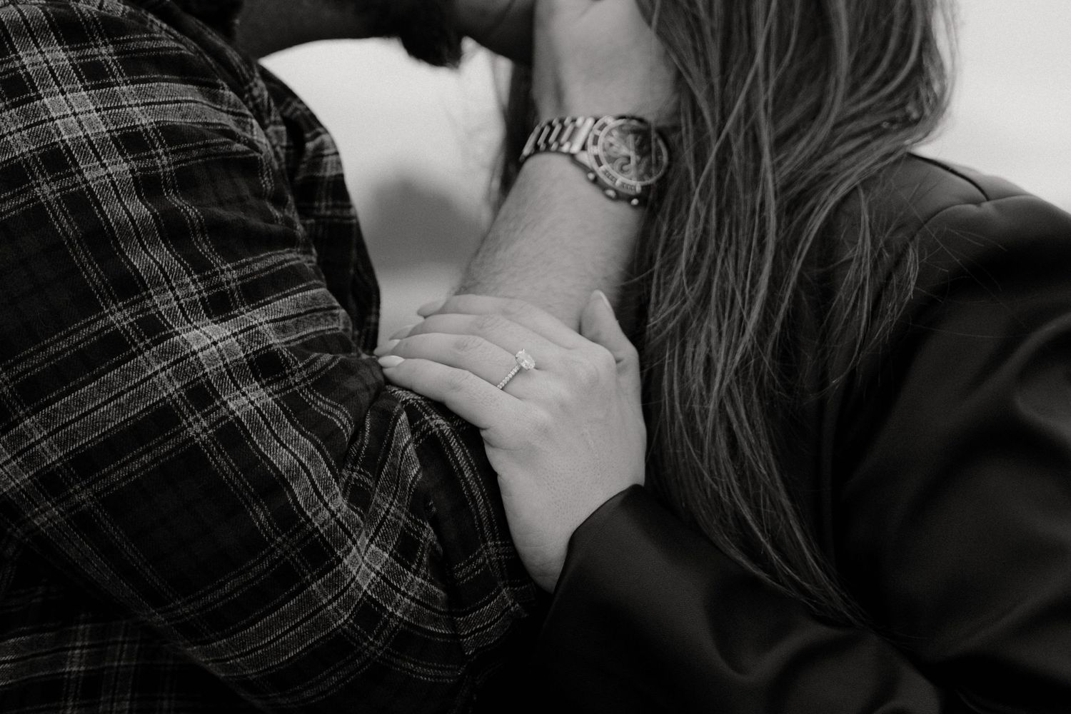 Intimate moment captured with plaid shirt and dark clothing against light background in Vancouver Island
