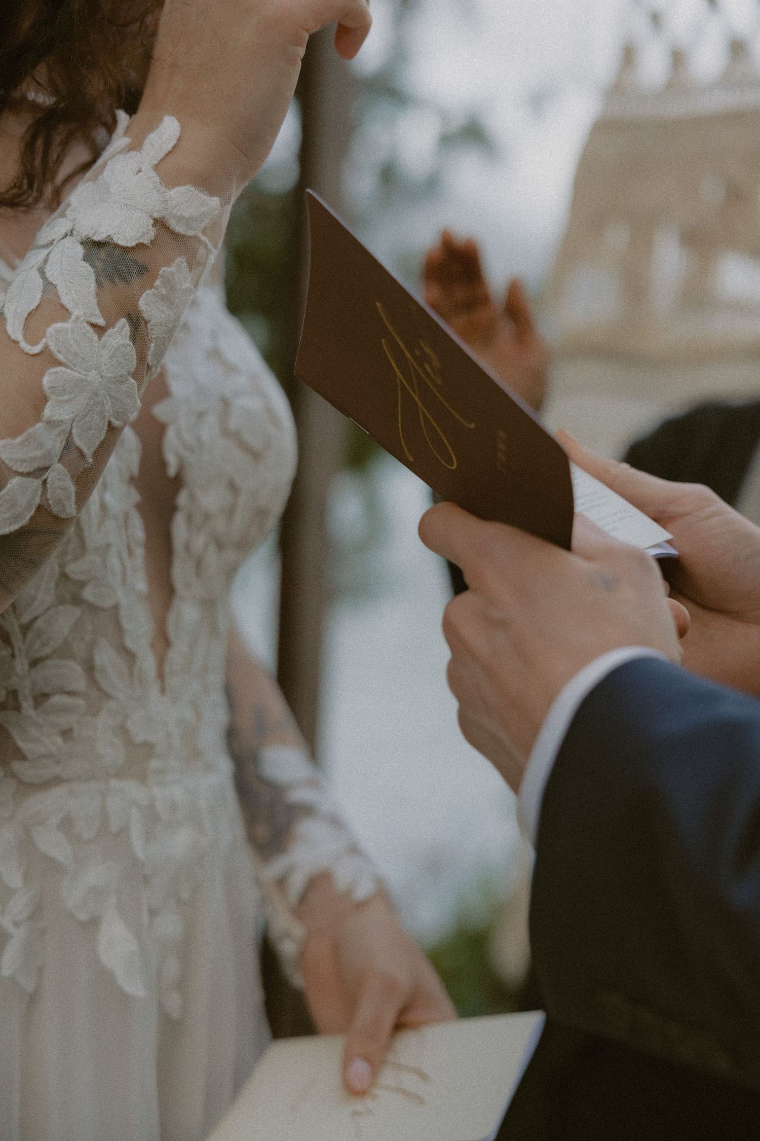 Close-up of lace wedding dress details during vow exchange