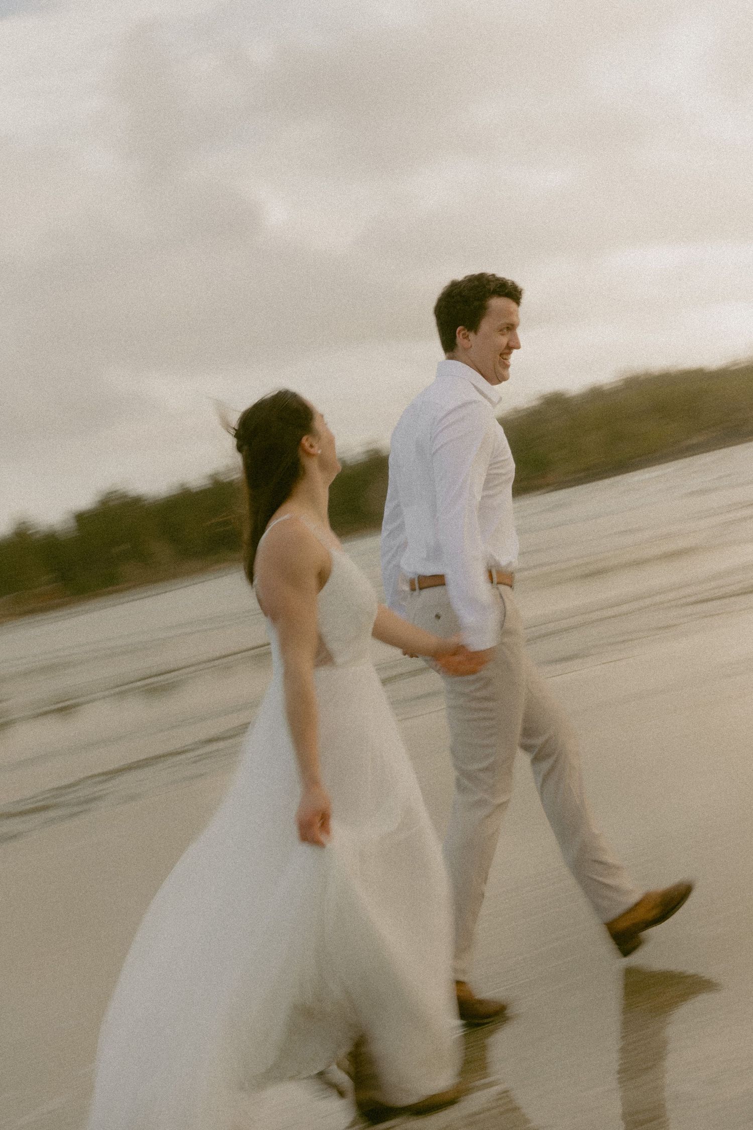 Tofino wedding couple running and playing along the Mackenzie Beach shoreline