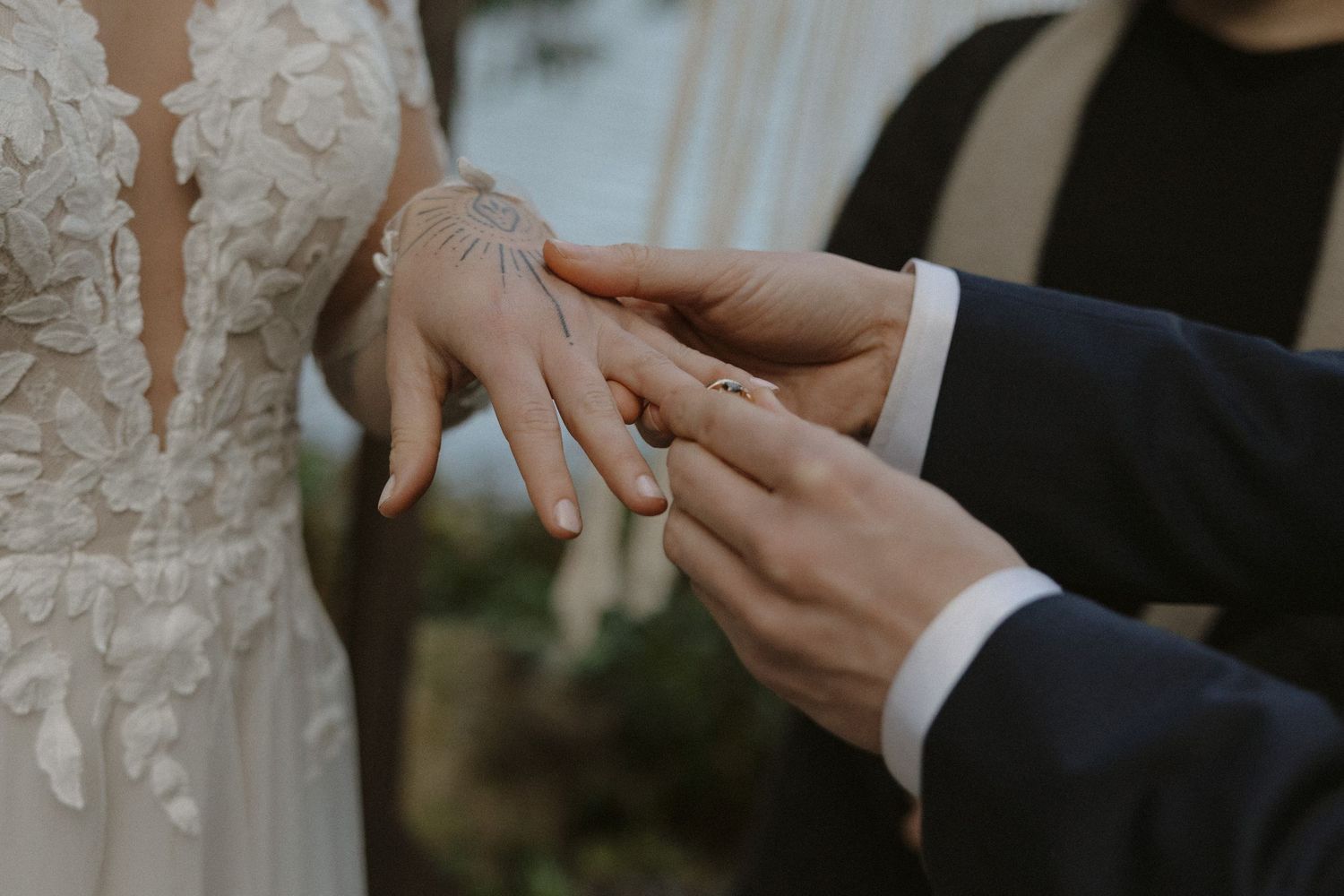 Close-up details of hands during an intimate wedding ceremony moment.