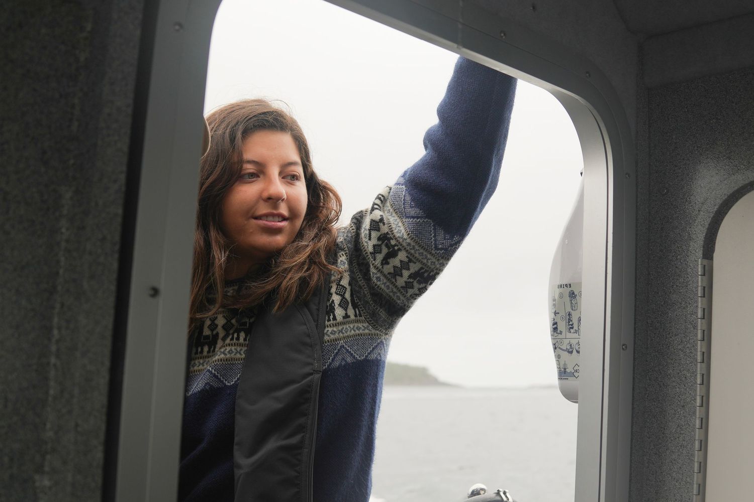 Tofino wedding photographer looking out of a boat window with a joyful expression