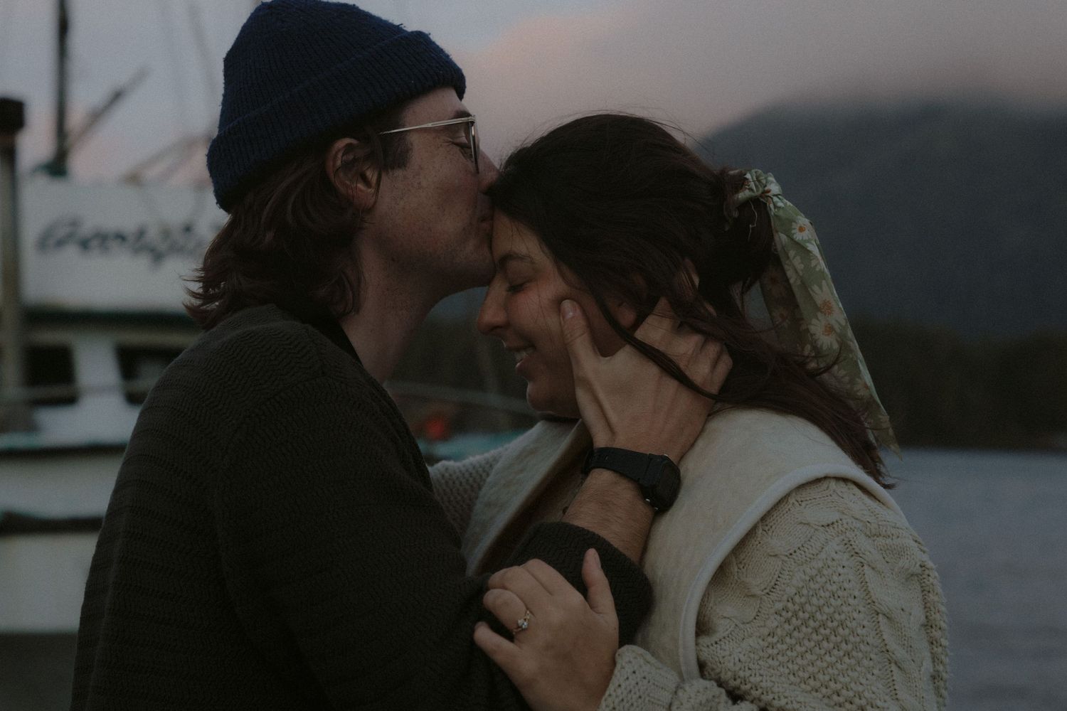 Couple sharing intimate moment while using binoculars at harbor.
