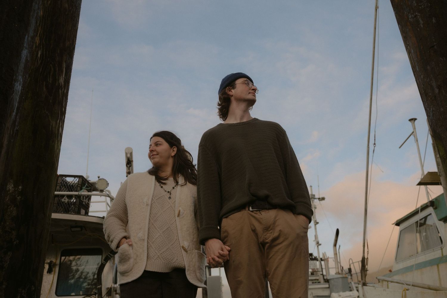 A candid moment captured between people on a harbor dock during golden hour.