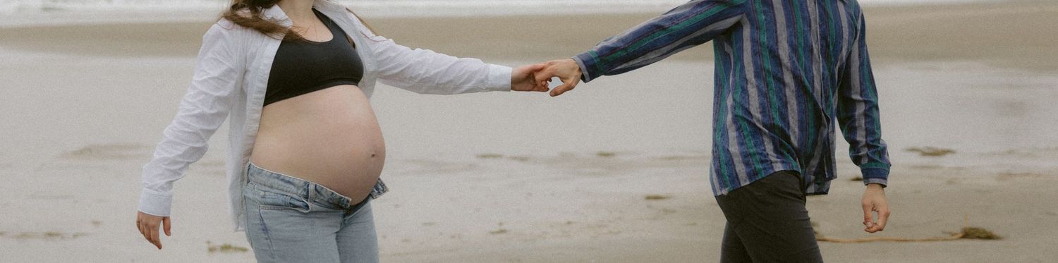 Friends enjoying a casual walk along the shoreline of a foggy beach.