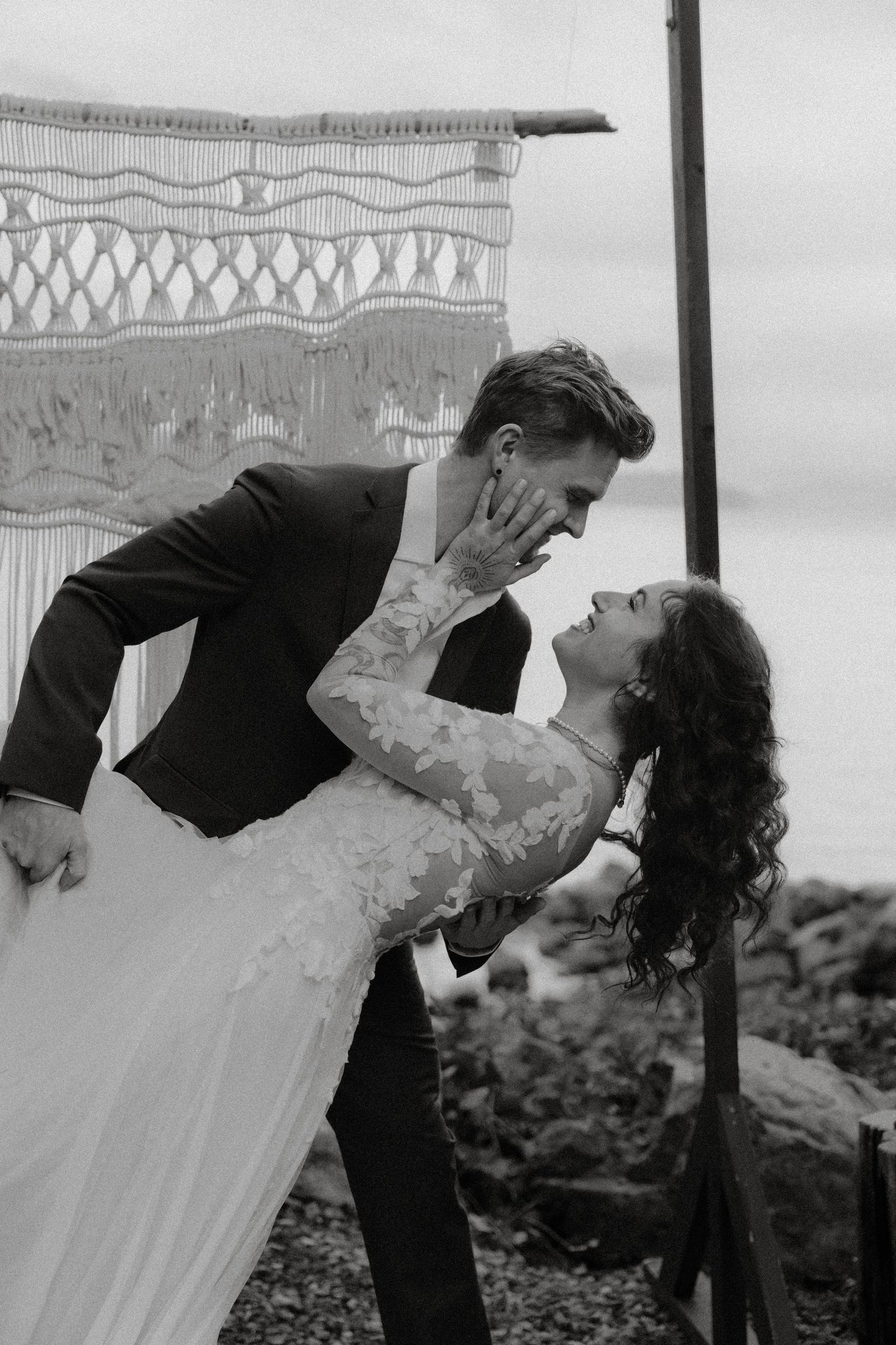 Tofino wedding couple in dramatic black and white dance dip pose against decorative backdrop