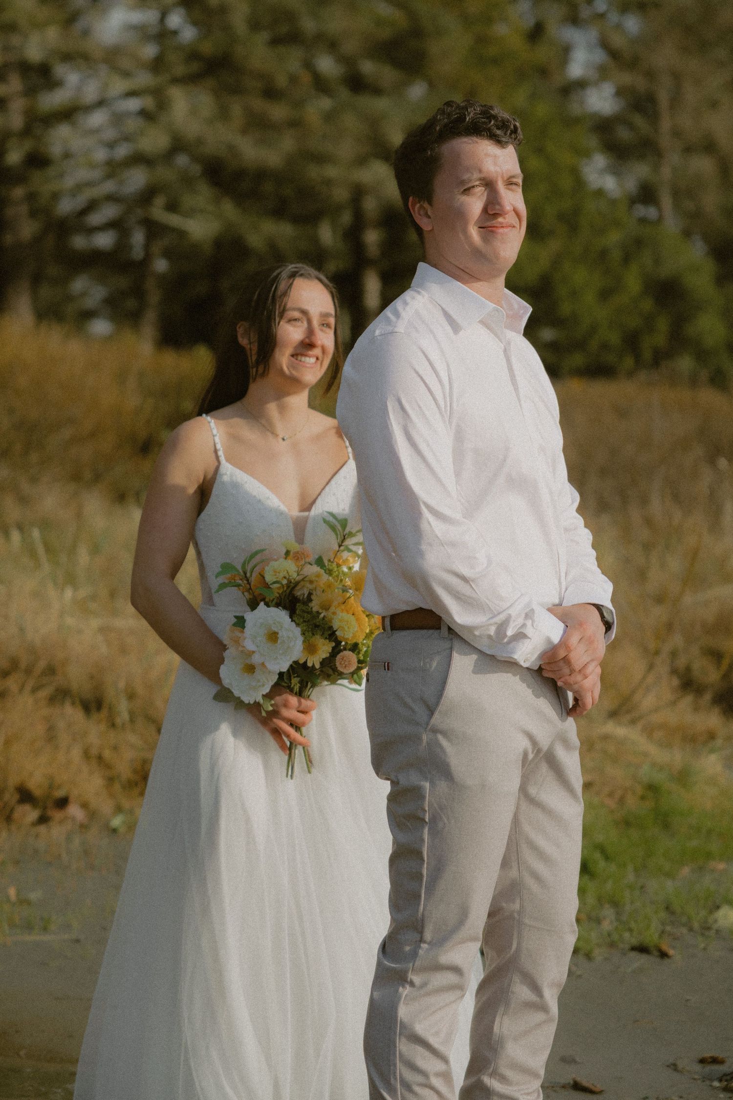 Tofino couple in wedding attire doing first look on Makenzie Beach in front of Bella Pacifica Campground