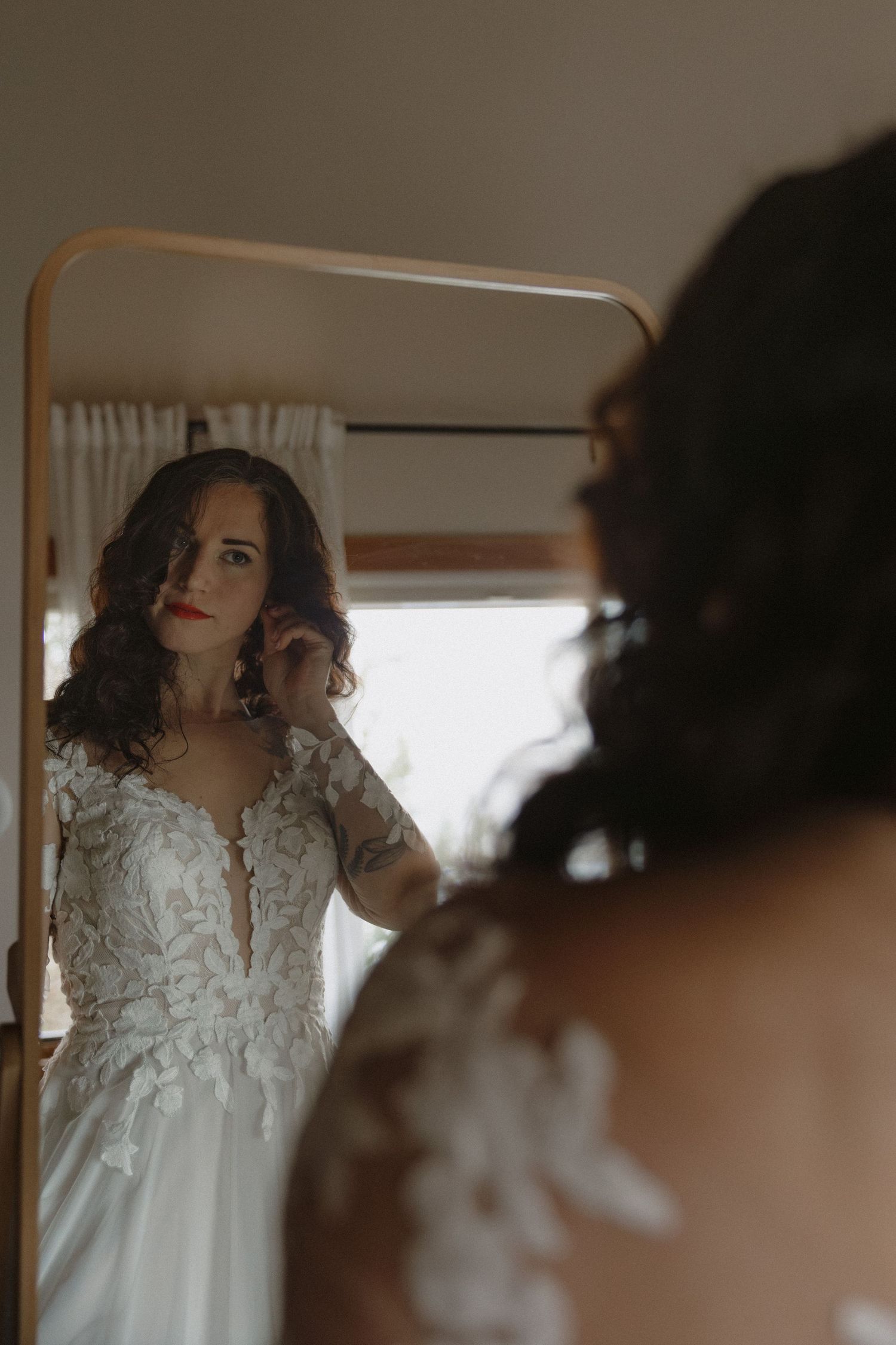 Elegant white lace wedding dress with intricate details photographed in soft natural light.
