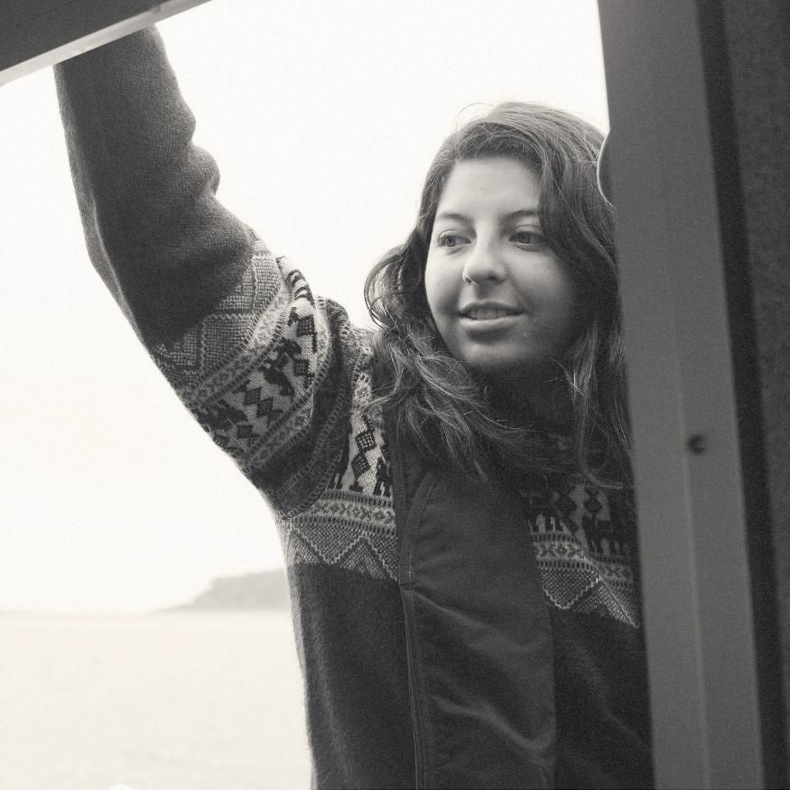 Tofino lifestyle portrait of Mariana in cozy winter sweater with arms raised