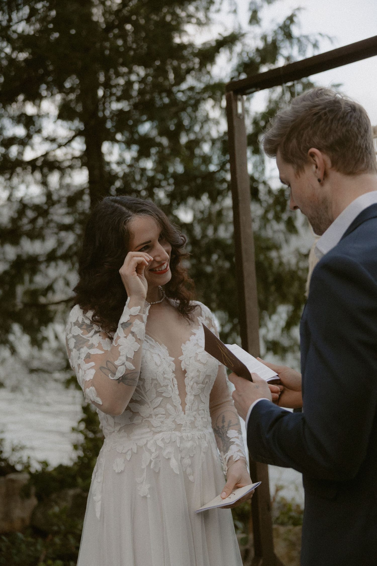 A Ucluelet couple sharing an emotional moment while reading vows outdoors in their wedding ceremony