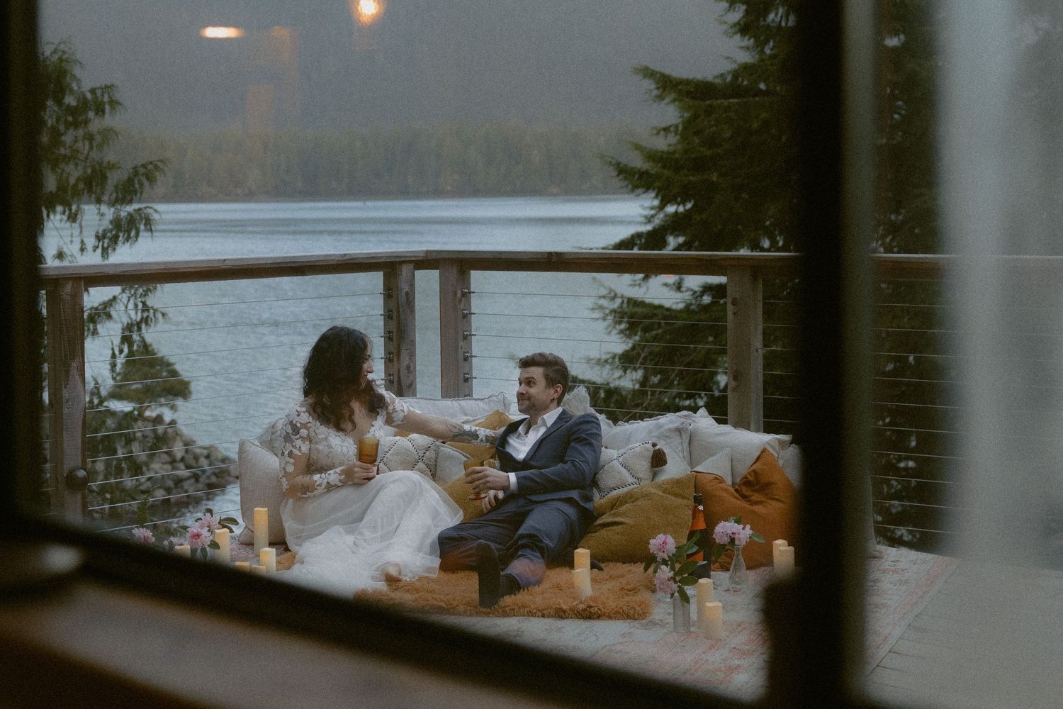 Tofino intimate wedding romantic dinner setting at dusk overlooking Clayoquot Sound with glowing lanterns and cozy seating