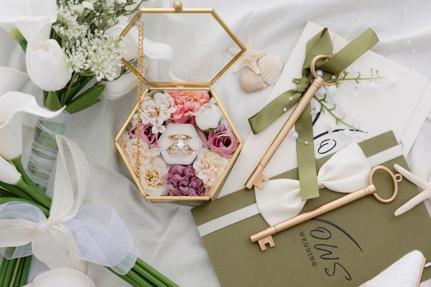 Wedding details with gold geometric box containing delicate flowers and white orchids.