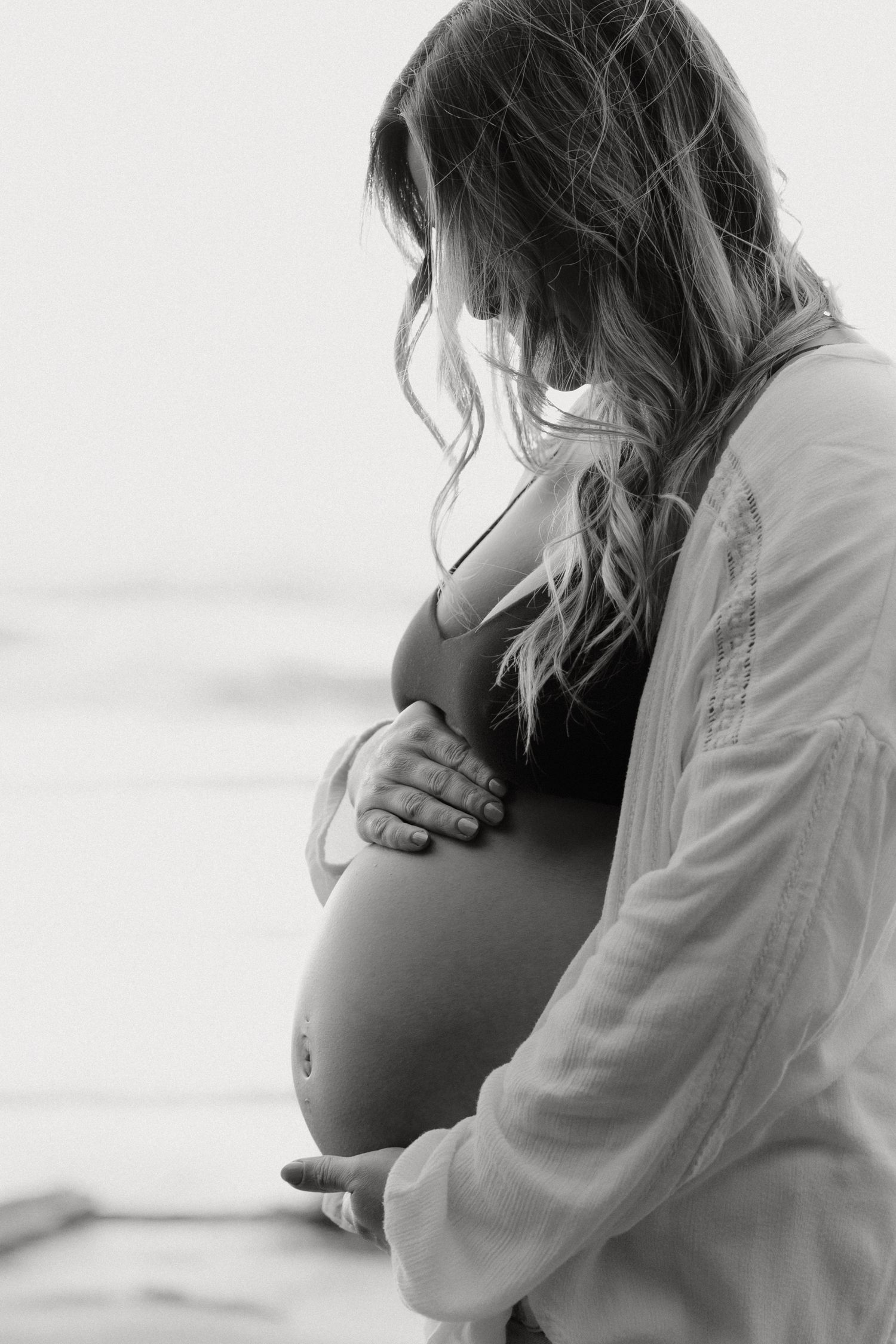 Serene beachside maternity portraits with soft natural lighting.