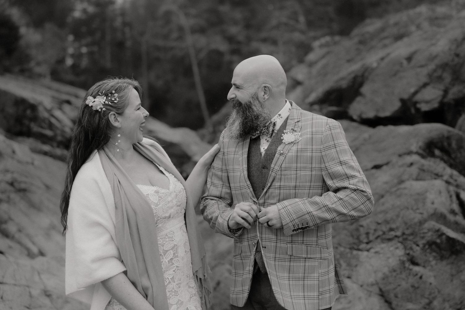 Black and white photo of couples sharing intimate moments among coastal rocks and cliffs.