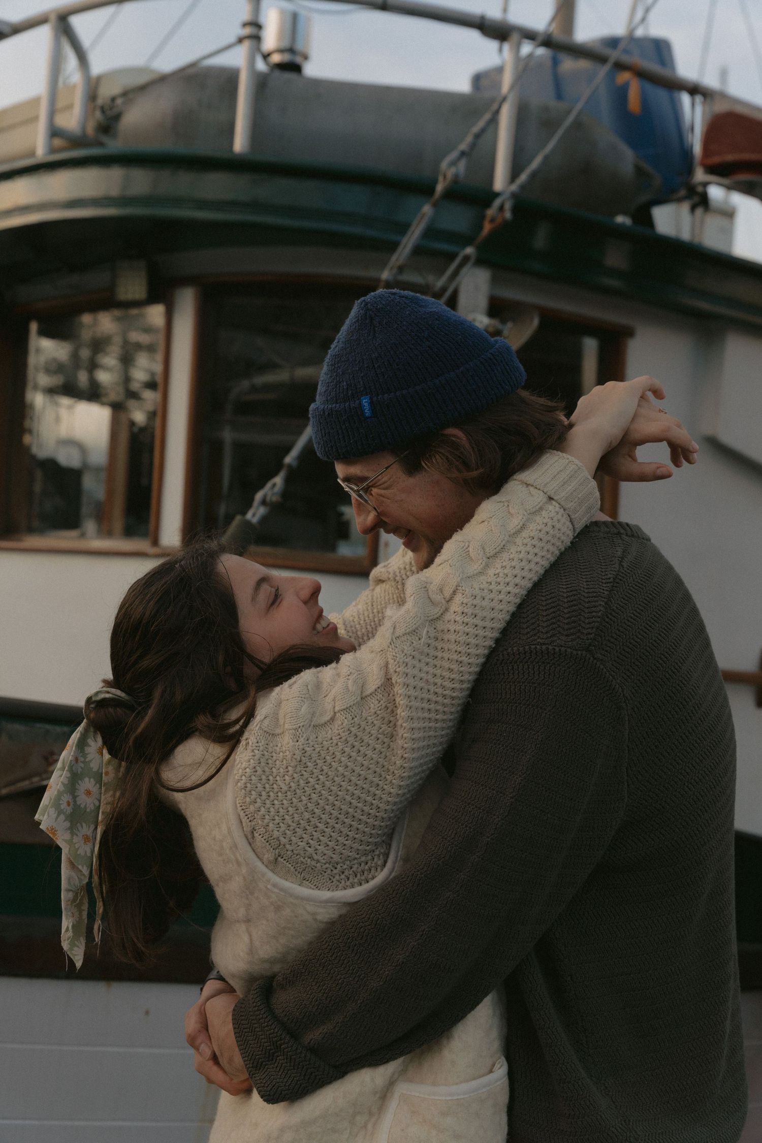 Tofino engaged couple sharing playful moments together in town near boats at a marina