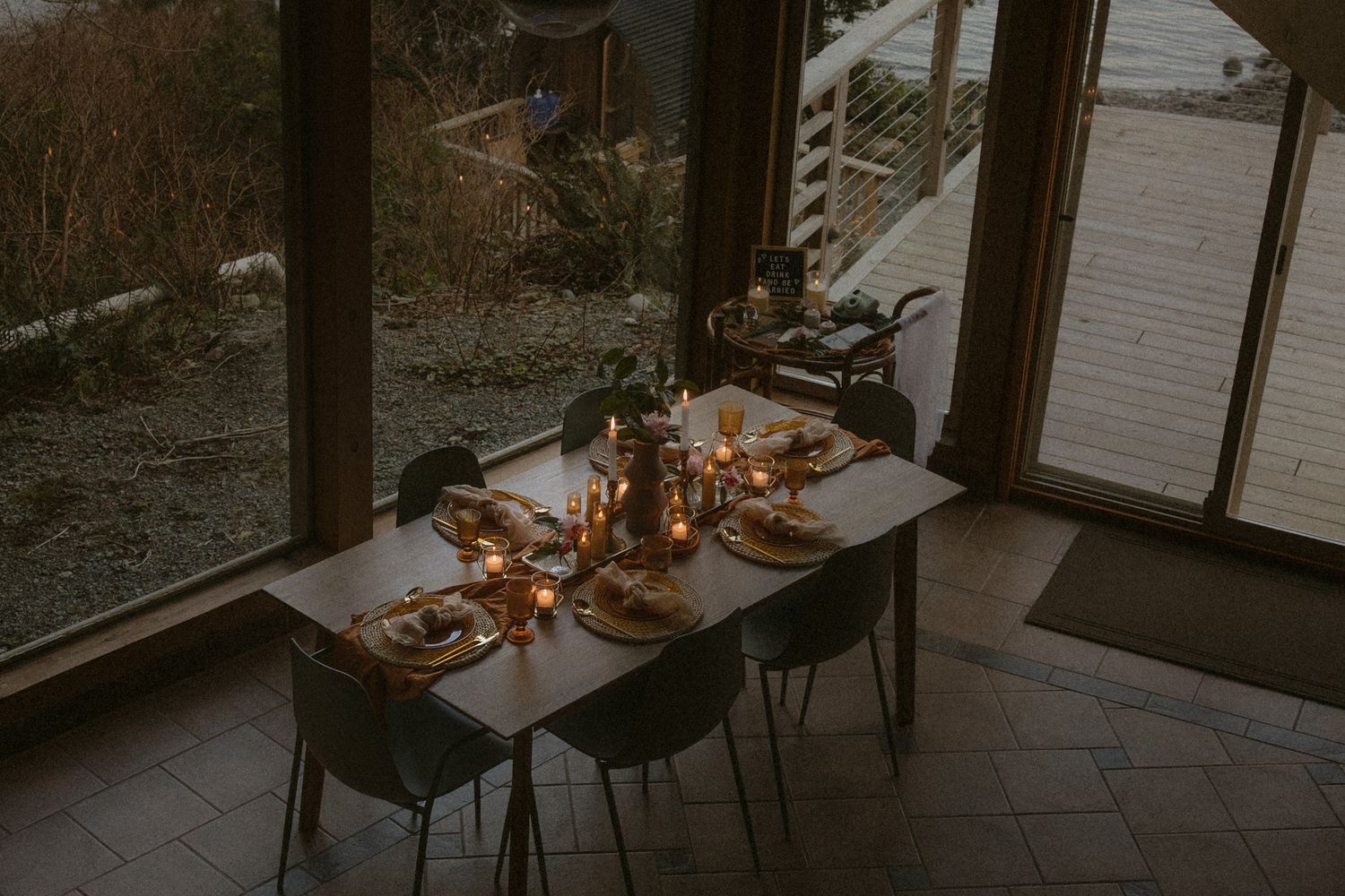 Tofino wedding reception dining room setup with dark chairs and ambient lighting