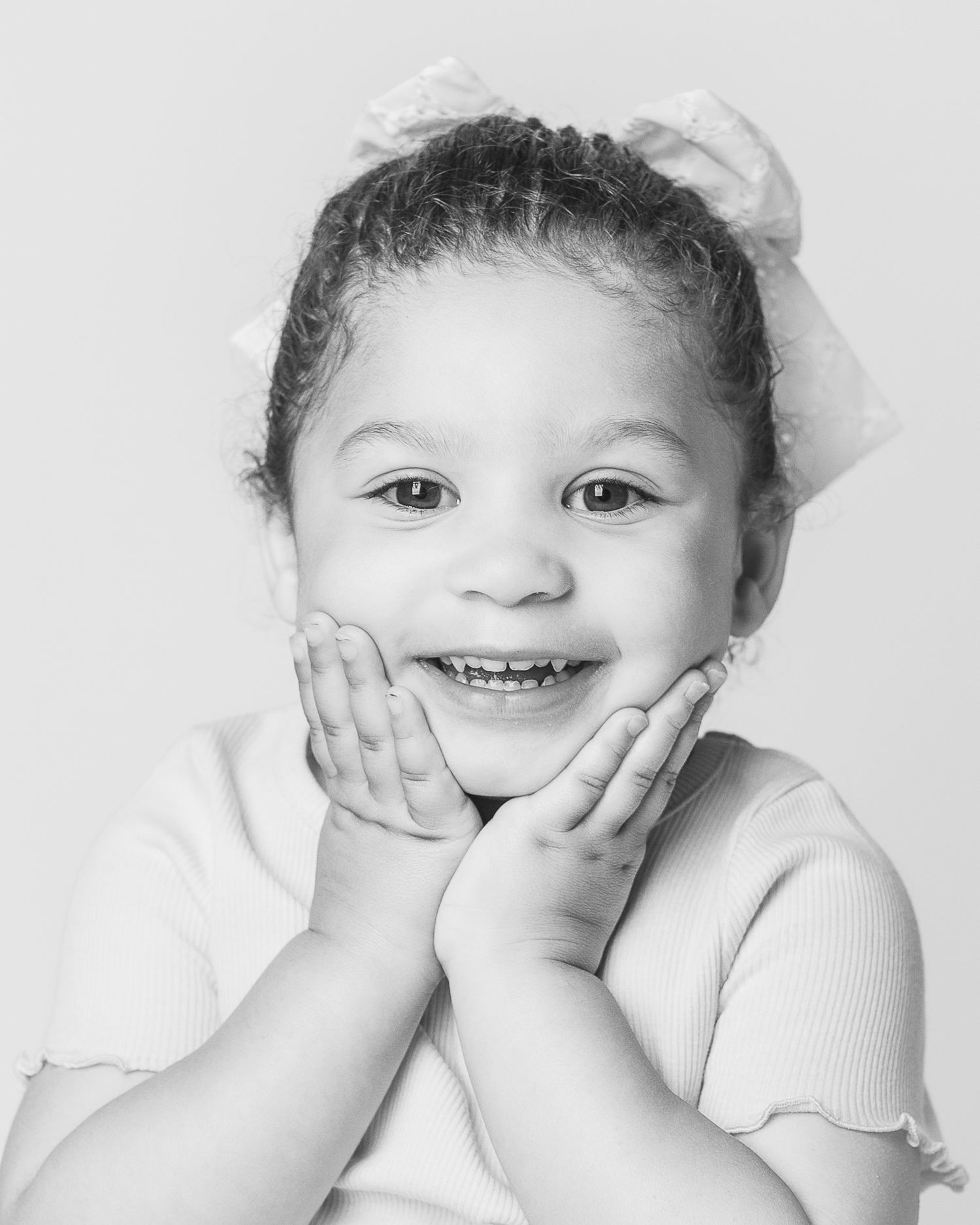 A beautiful portrait of a little girl with hands on her chin during a studio photography session by Ohio photographer, FRAMED.