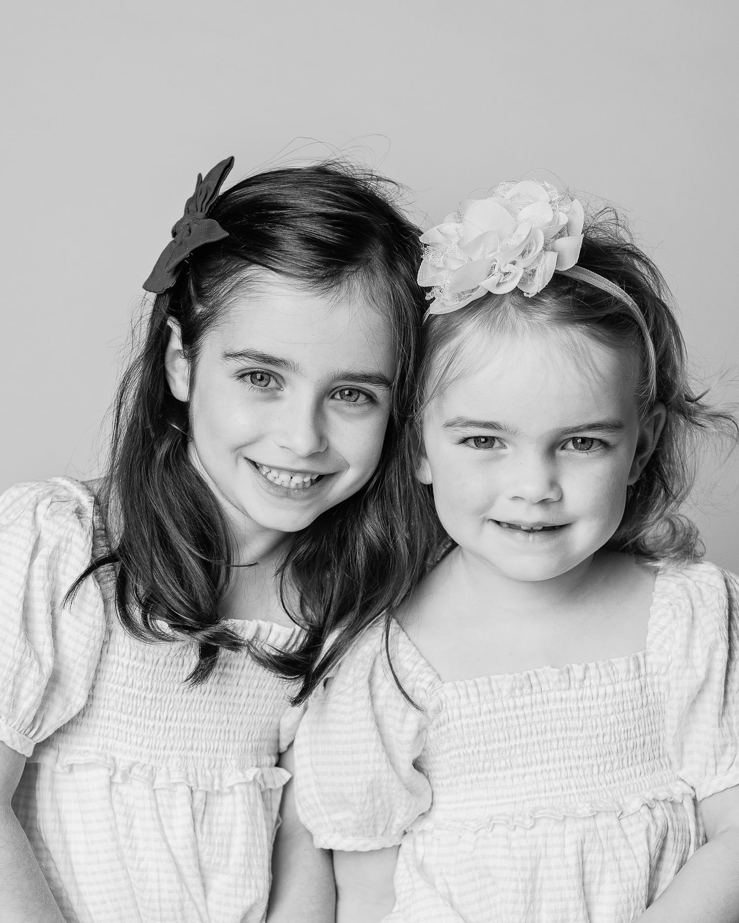 A black and white portrait of sisters capturing connection and personality by Northeast Ohio personality portrait photographer, FRAMED.