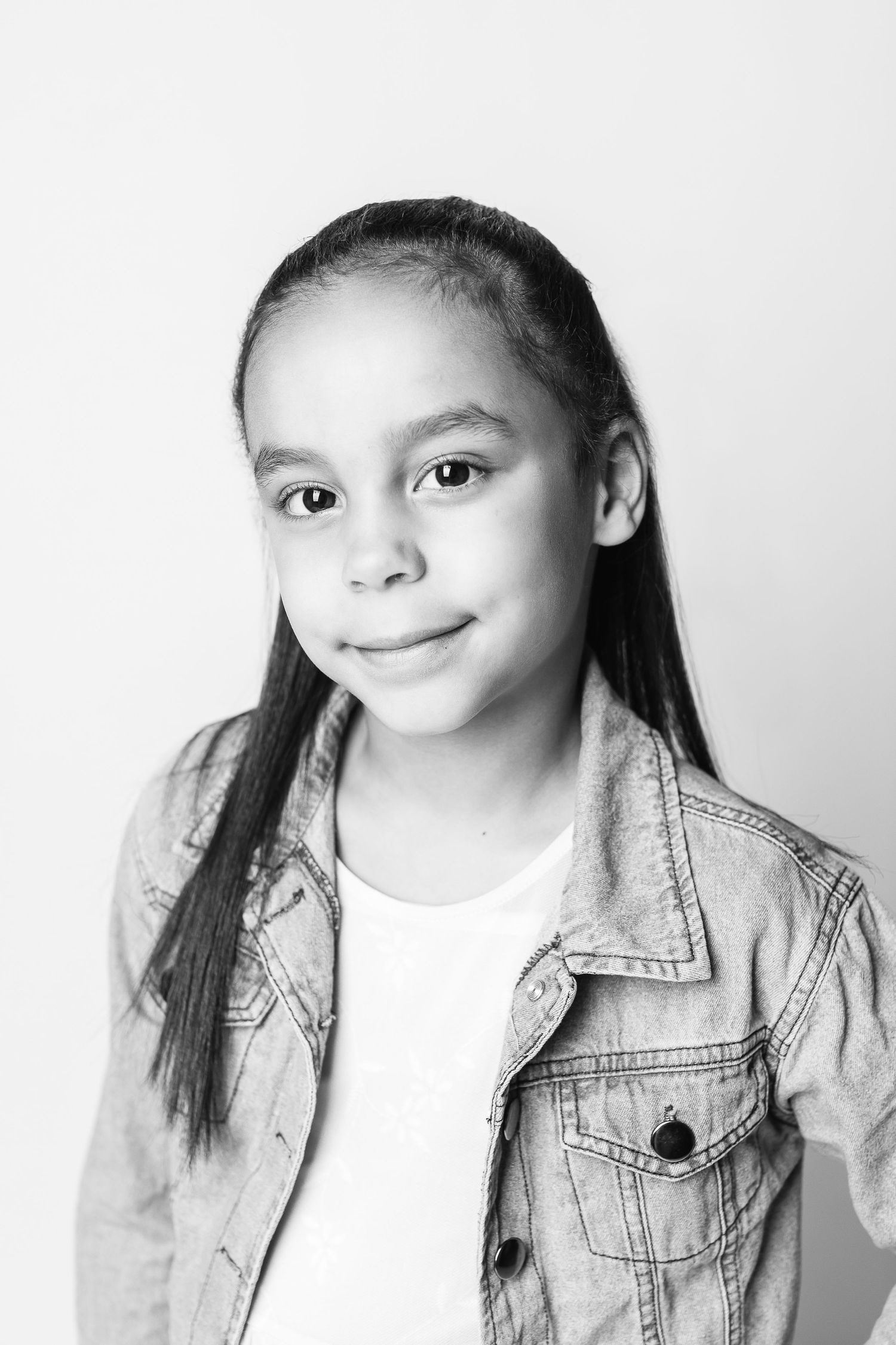 A black and white studio portrait capturing the personality of a young girl by a portrait photographer in the Cleveland, Ohio area.