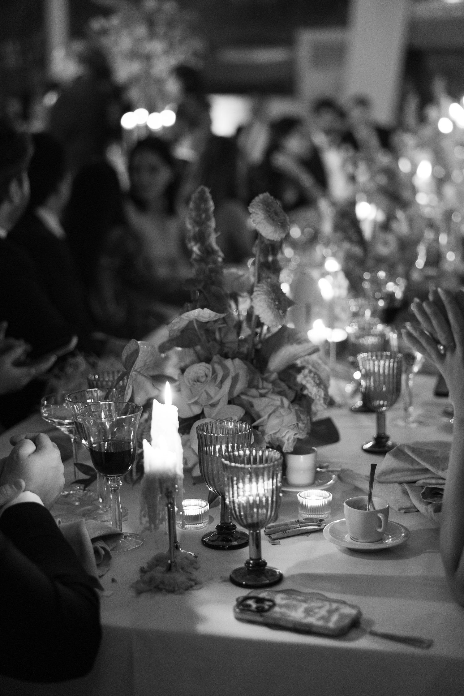 Candlelit wedding reception table with elegant floral centerpieces and crystal glassware.
