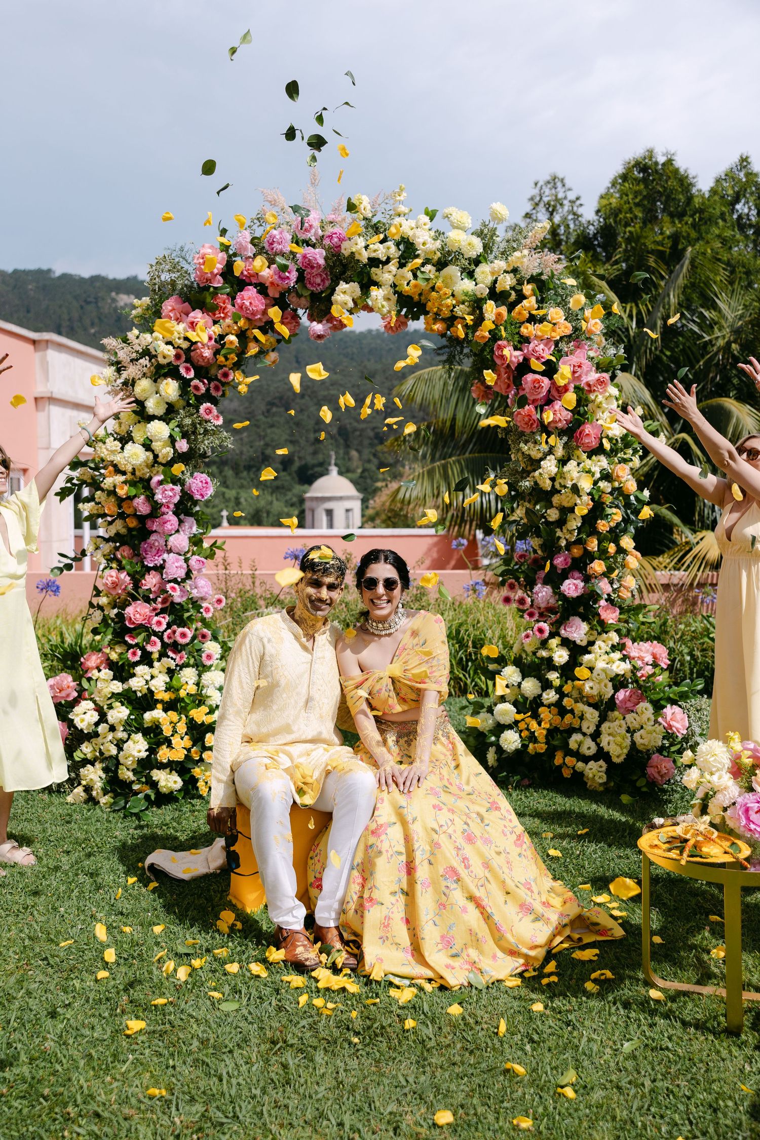 Joyful wedding celebration with yellow theme and floral arrangements in outdoor garden setting.