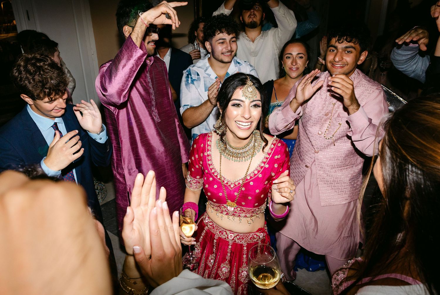 Wedding guests dance and celebrate at a vibrant reception party.