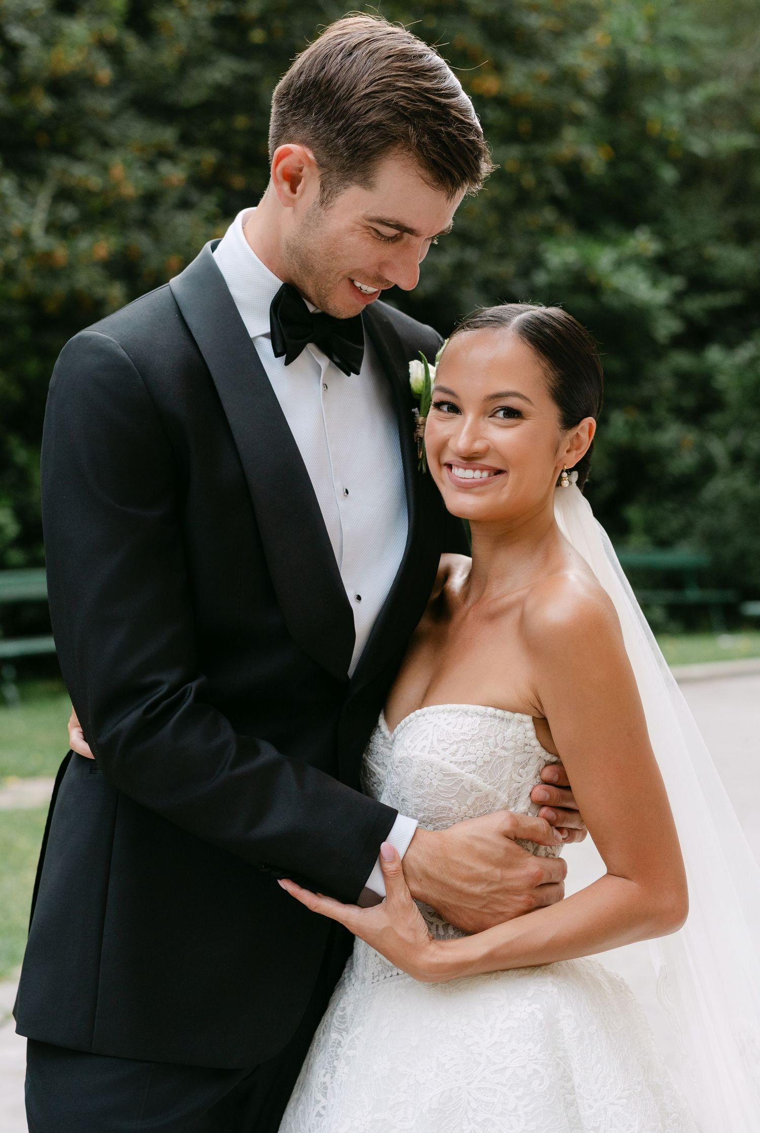 Newlyweds share an intimate moment in formal wedding attire.