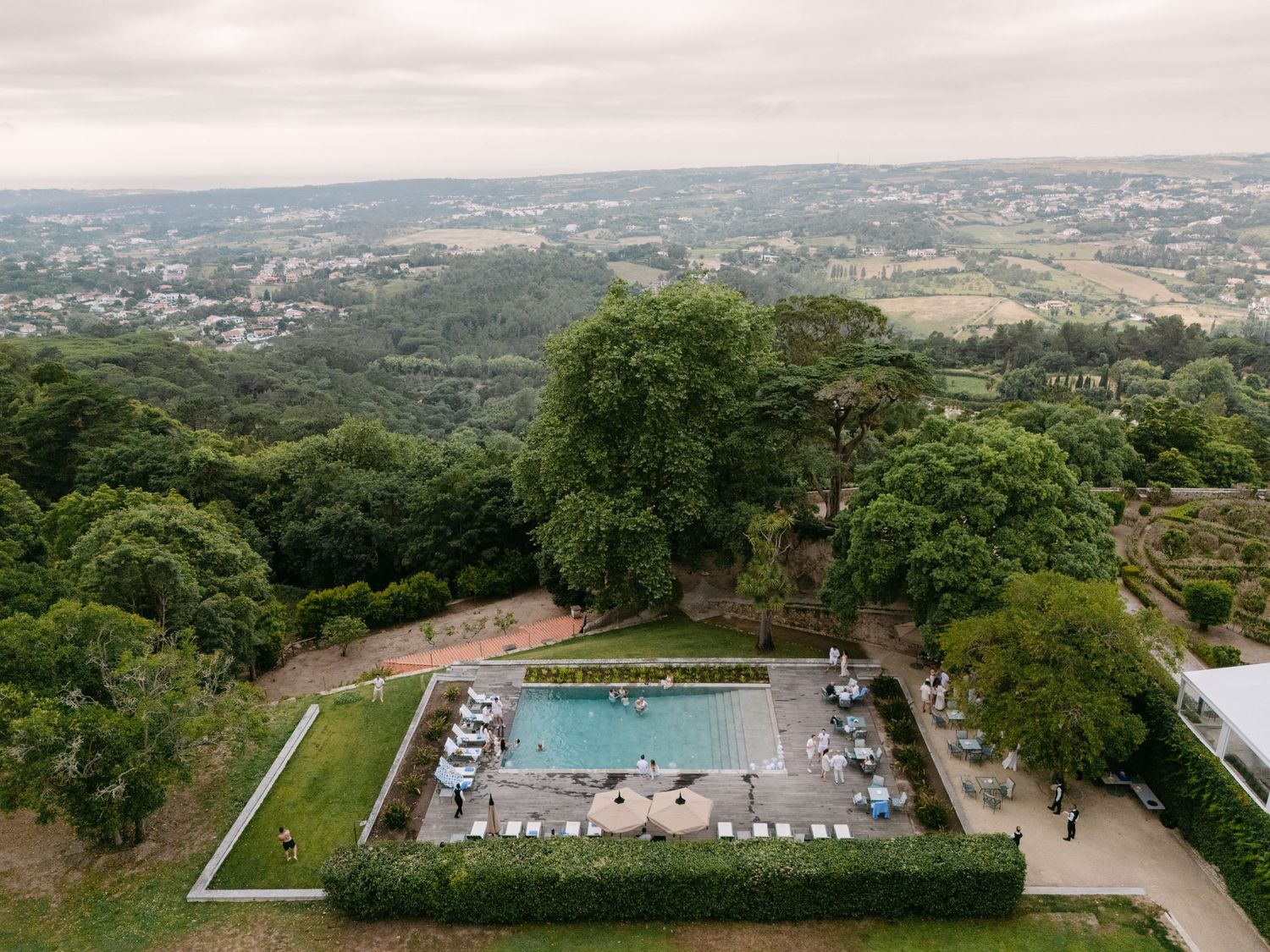 Aerial panorama of a luxury venue with swimming pool and landscaped gardens.