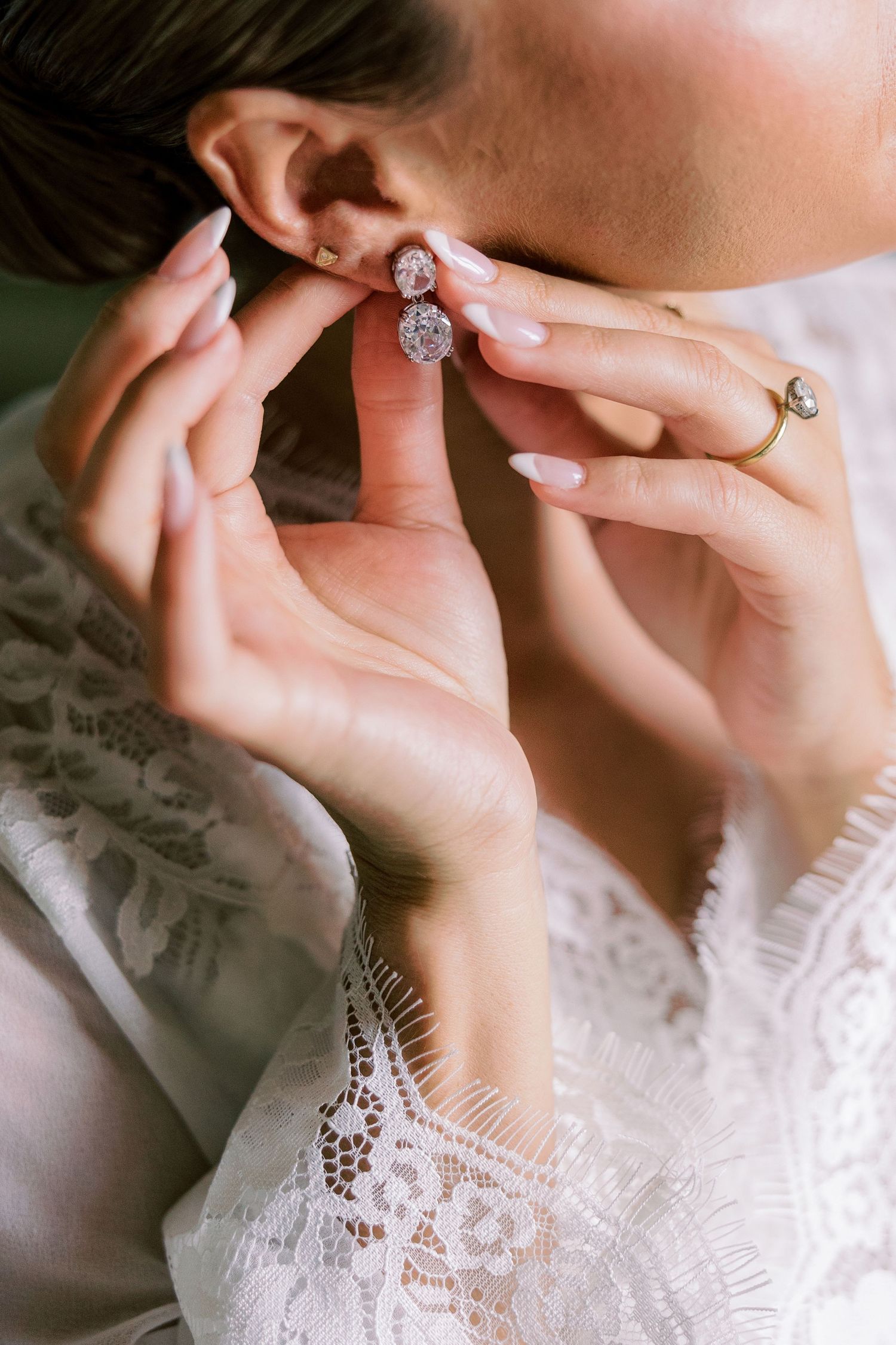 Close-up shots of hands displaying an engagement ring with delicate lace details.