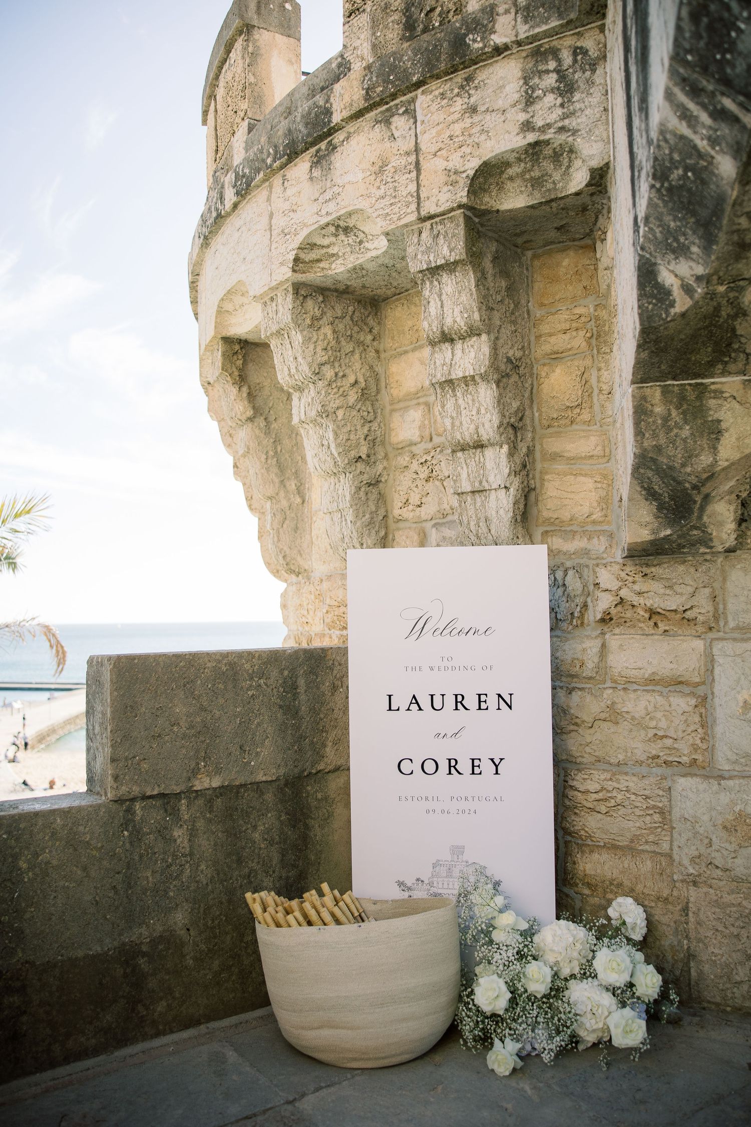 Wedding signage and floral decorations displayed along ancient stone castle walls.