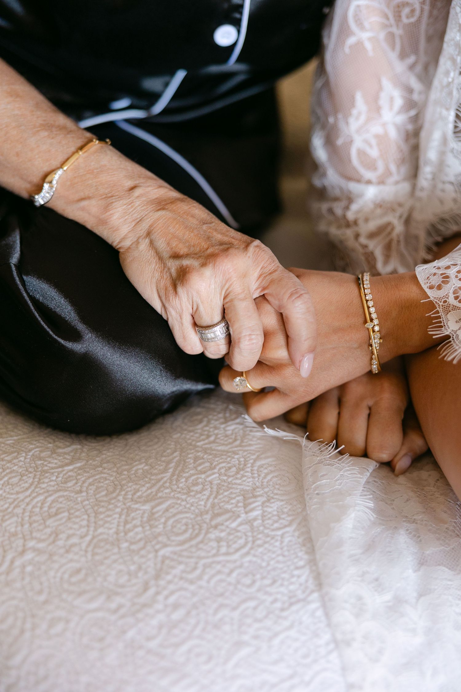 Close-up shots of hands with wedding rings and bracelets against white lace fabric.