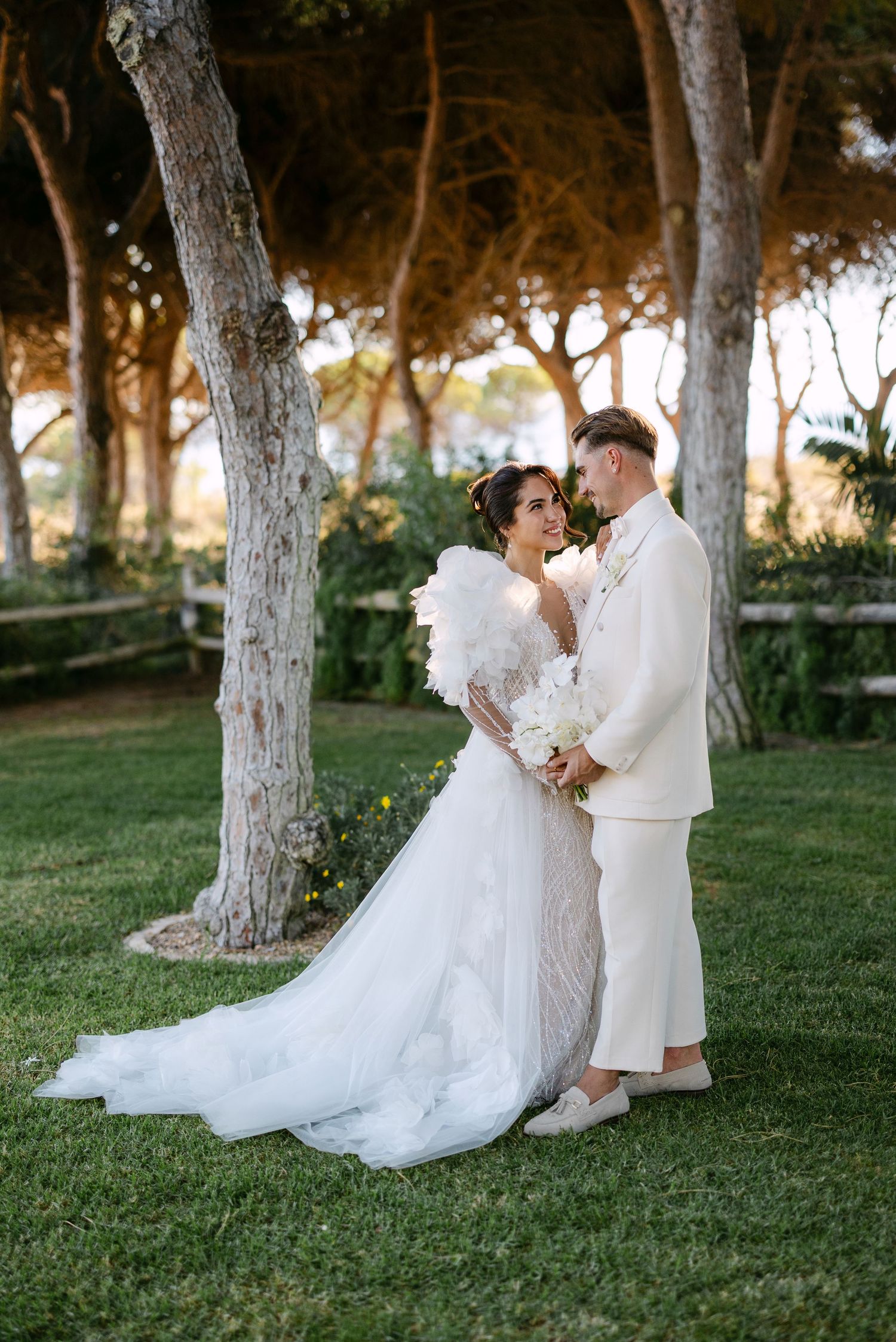A romantic wedding photoshoot under trees in a garden setting.