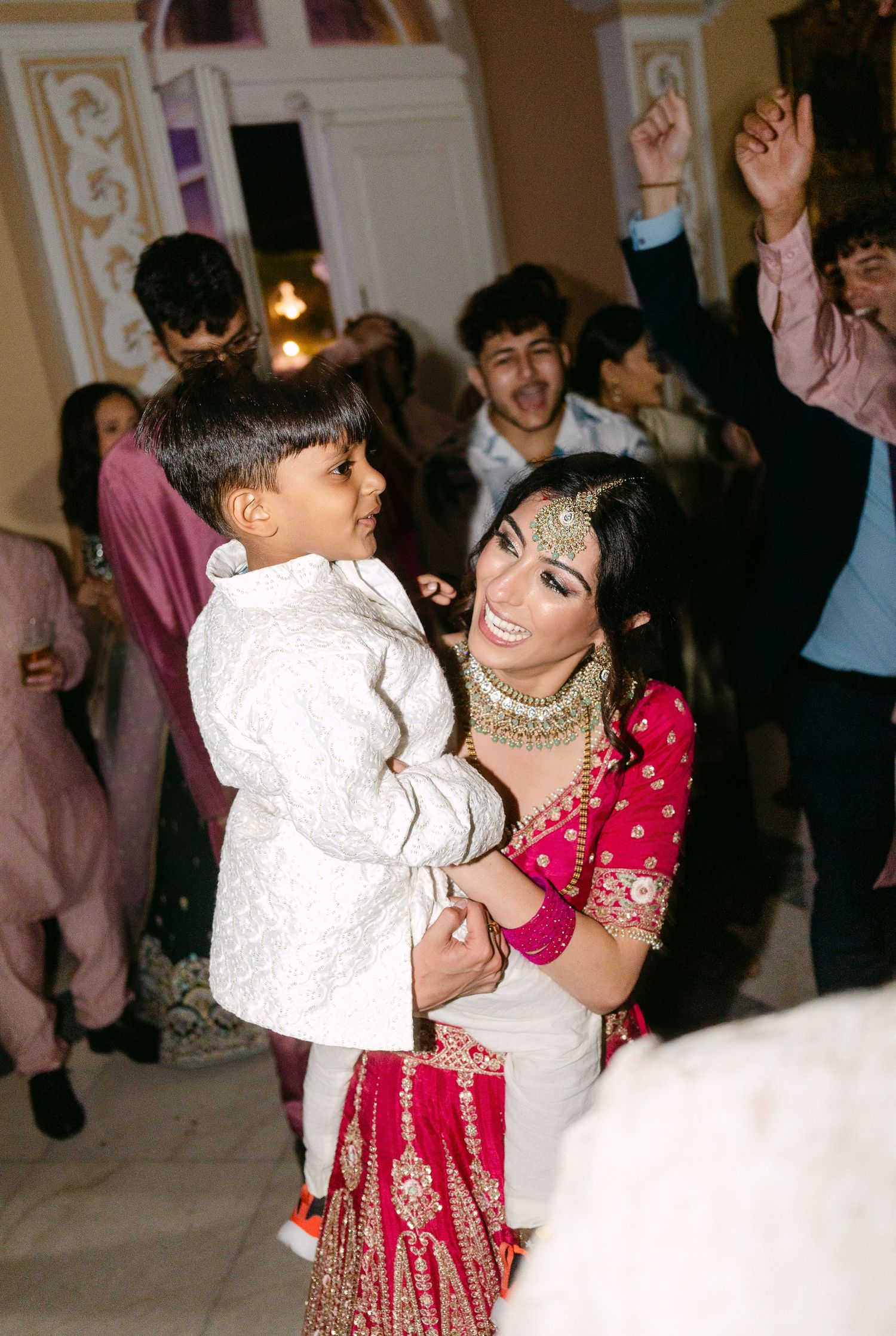 Wedding reception dance floor with guests in traditional Indian attire celebrating.