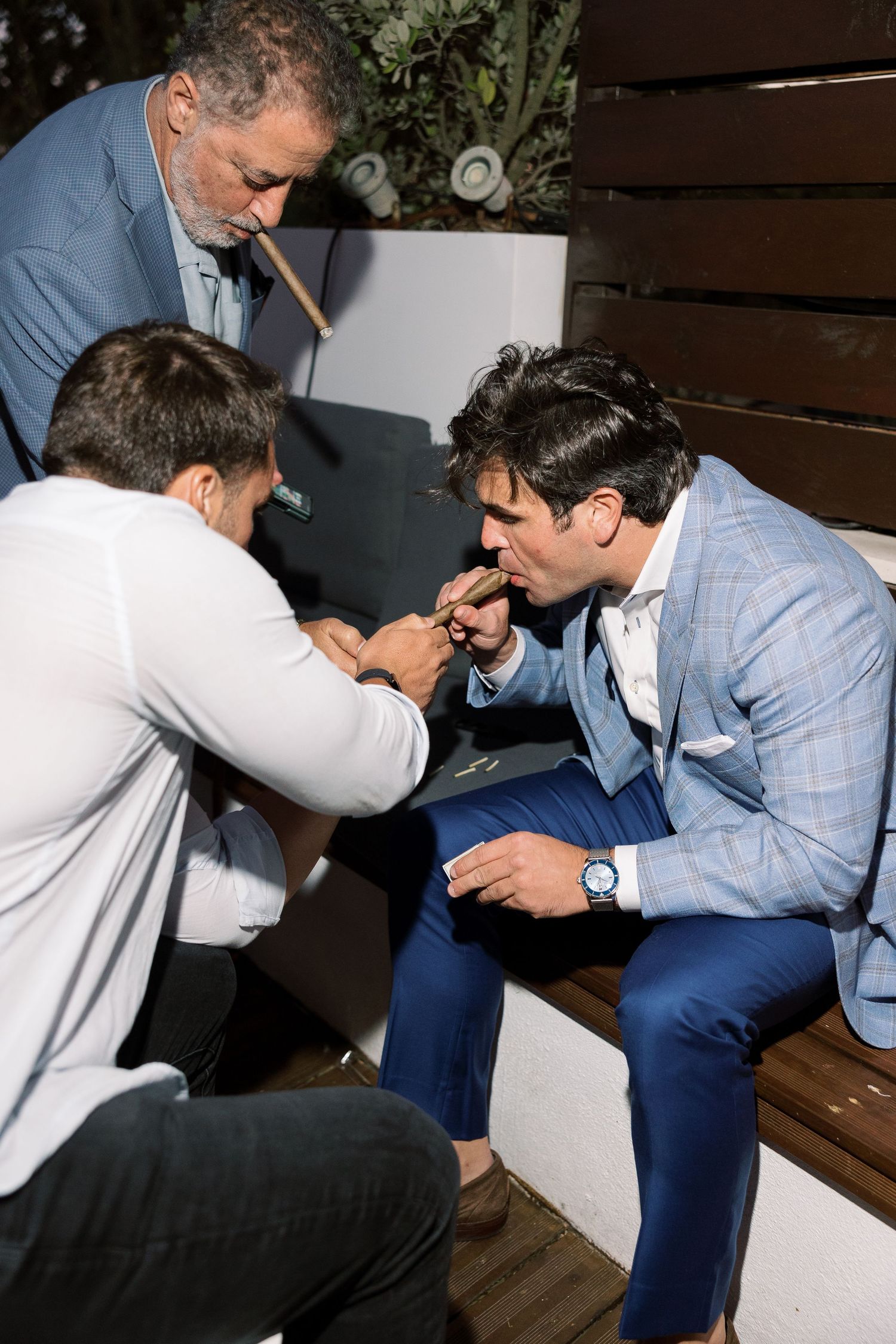 Wedding party members in suits playfully interacting during celebration.