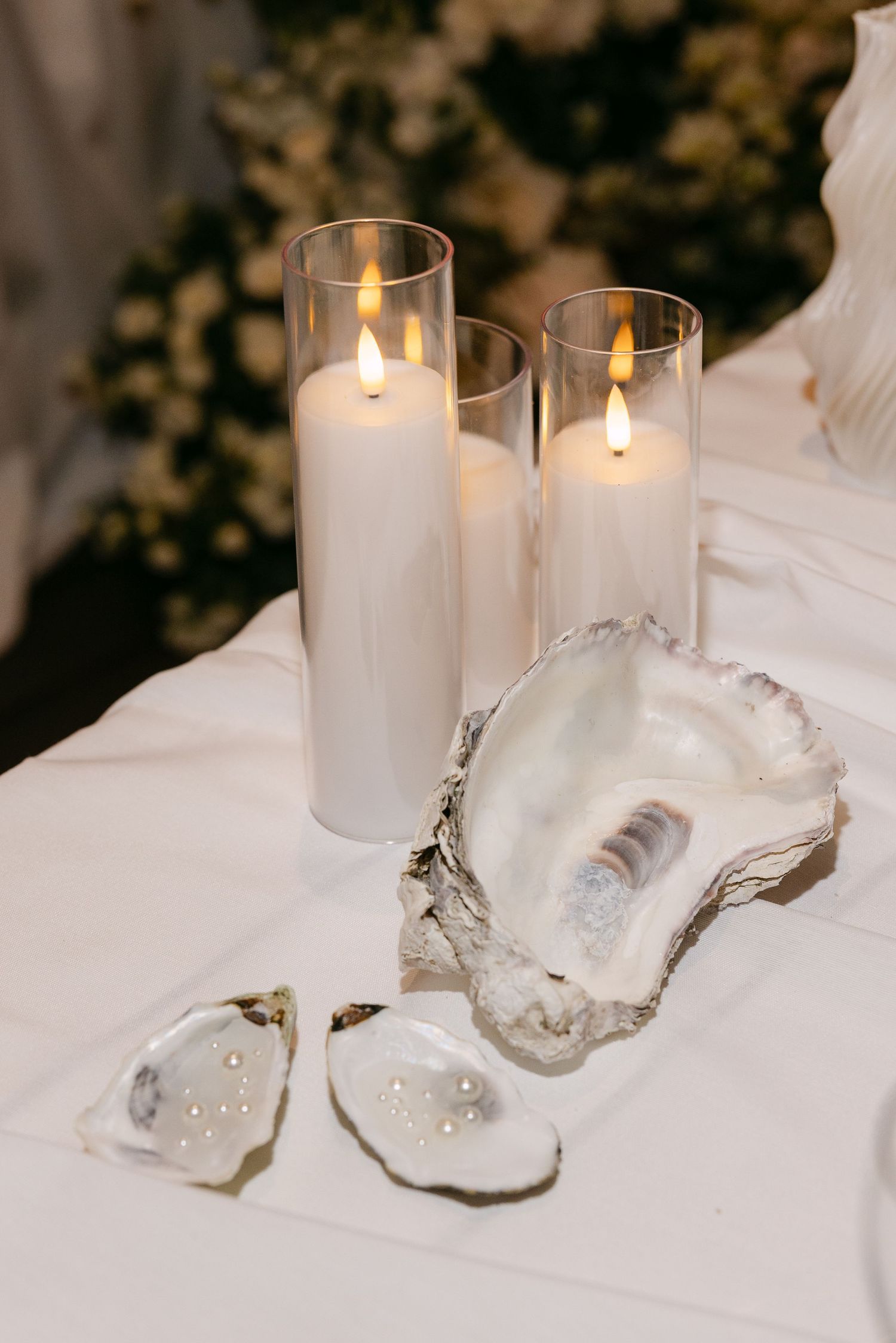 White candles and crystal decorations arranged on elegant table setting.