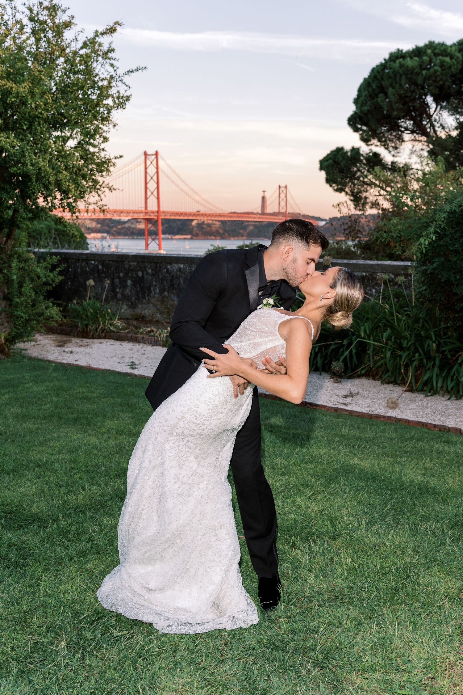 Romantic couple poses in front of the Golden Gate Bridge during sunset on their wedding day.
