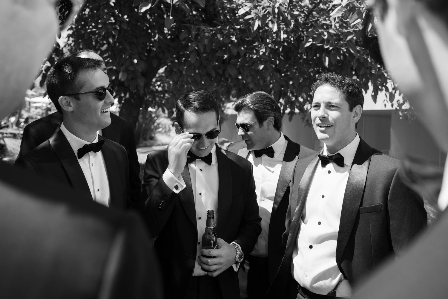 Groomsmen in tuxedos gathered together at formal event.