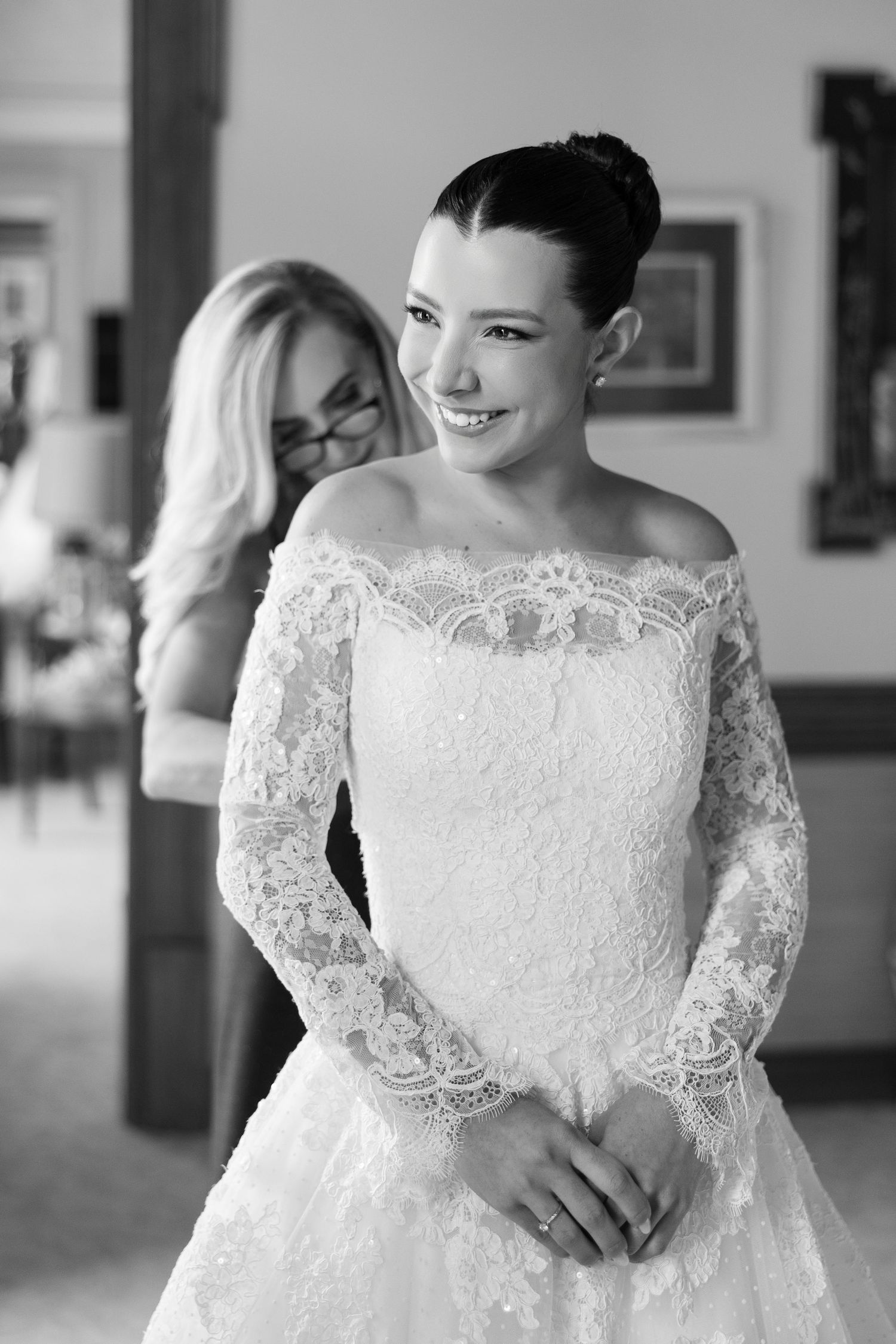 Elegant off-shoulder wedding dress with detailed lace bodice in black and white.