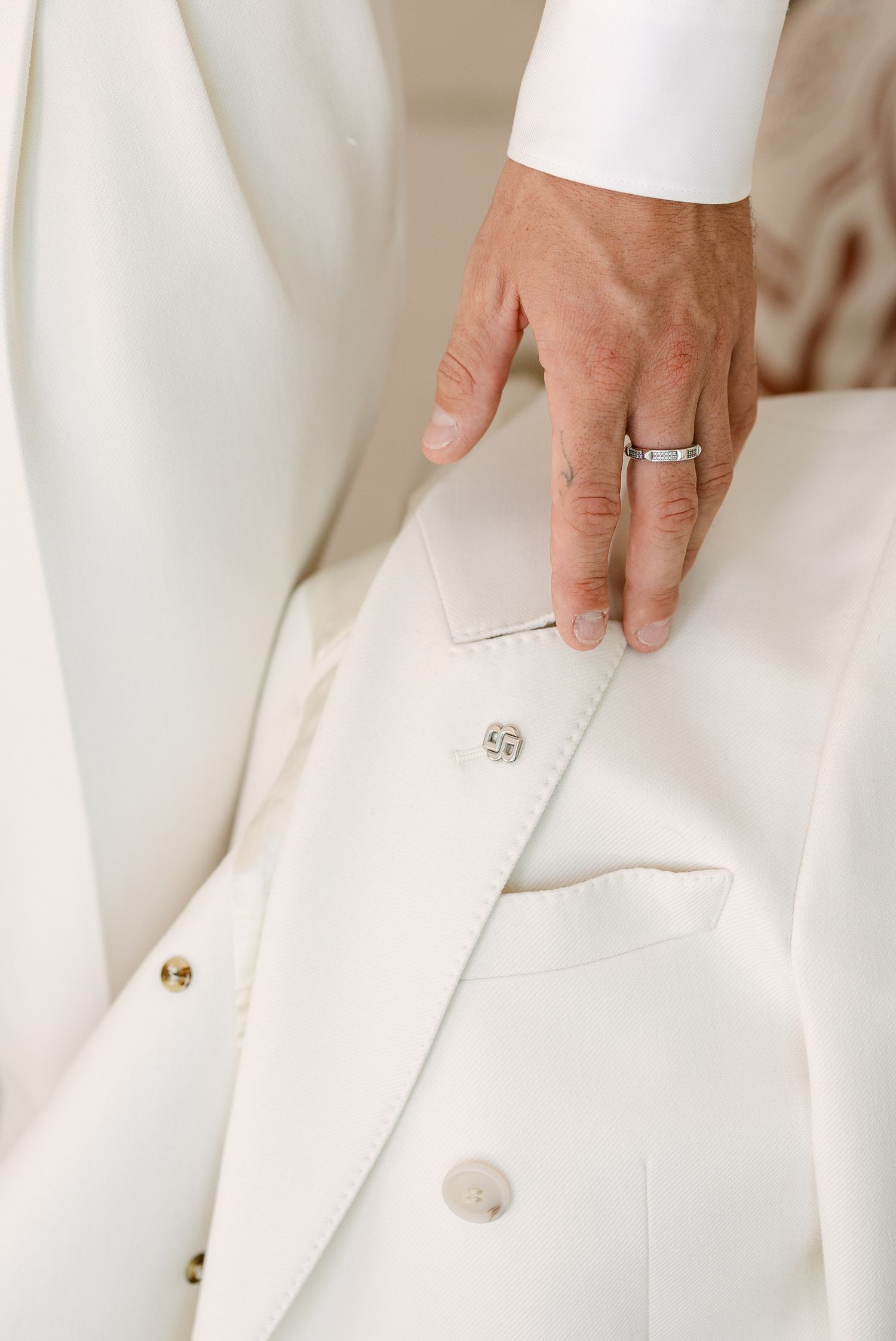 Detail shots of white formal attire with buttons and pockets.