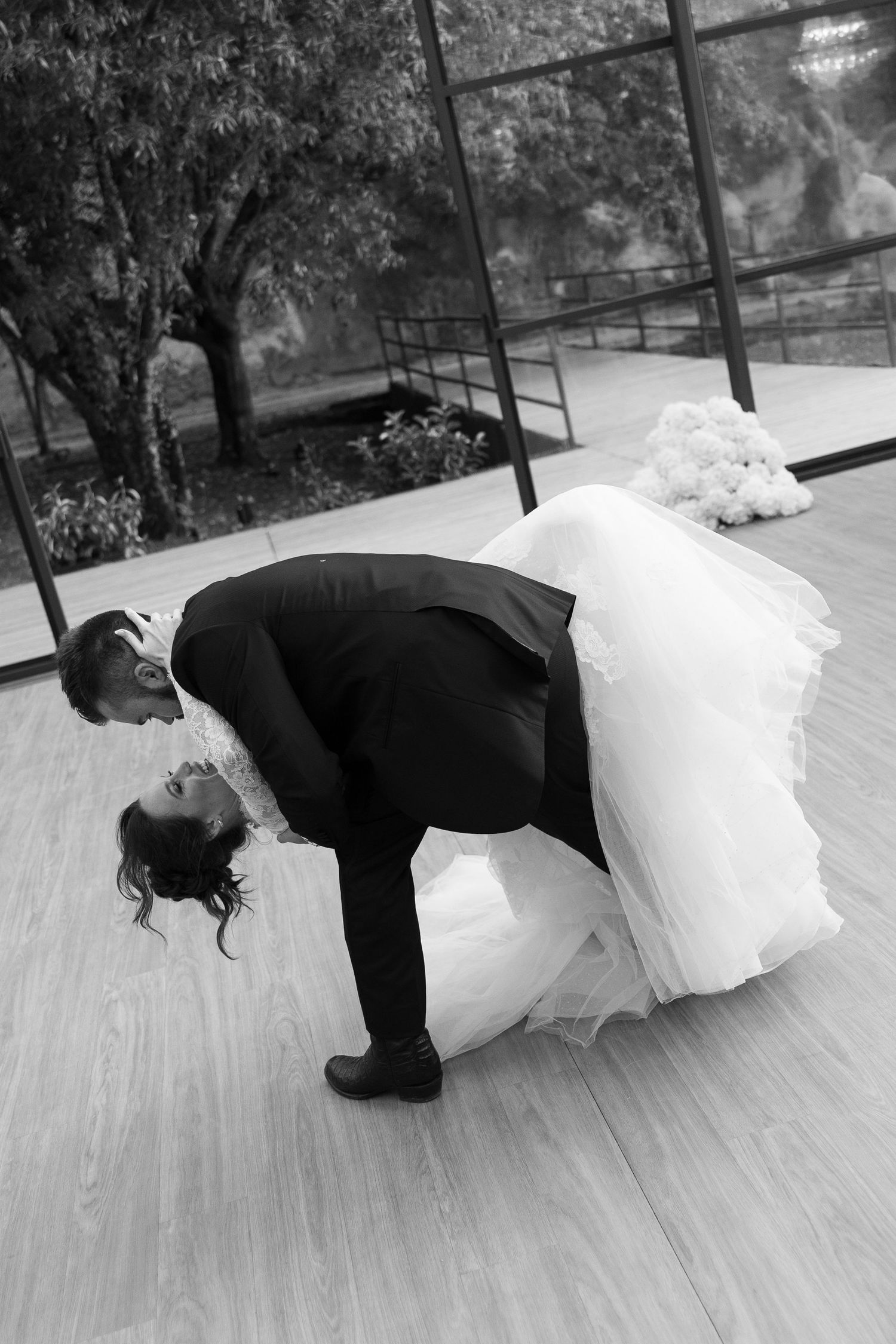Artistic black and white dance performance on wooden floor.