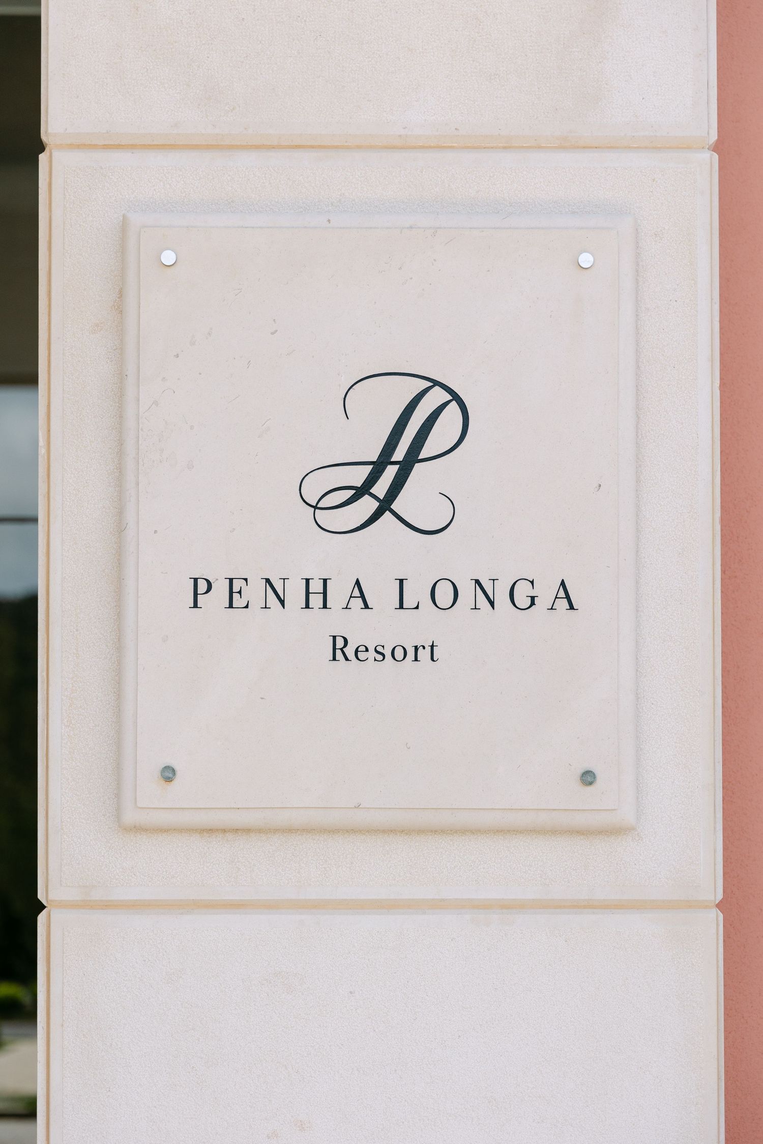Elegant Penha Longa Resort signage mounted on light colored wall.