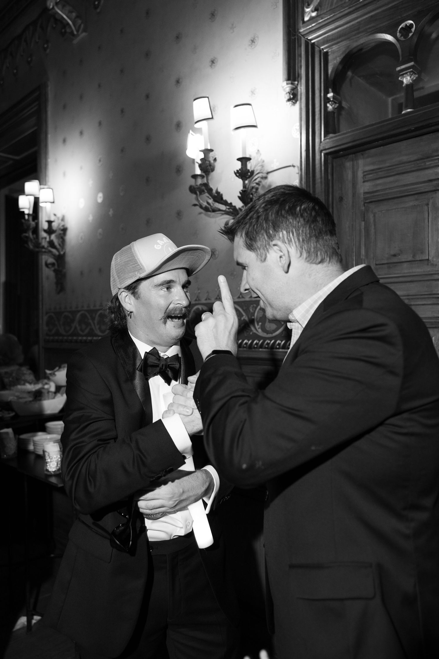 Two guests sharing a playful moment at an elegant wedding reception.