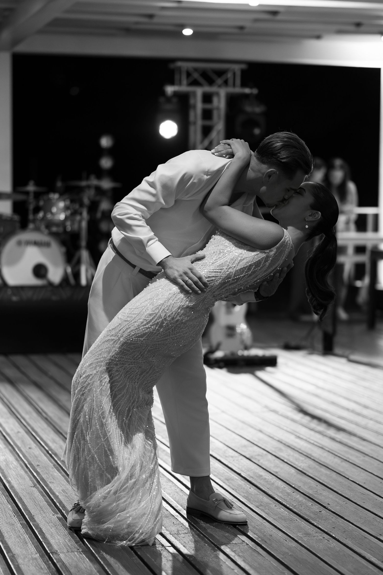 A romantic dance sequence showing a couple in white performing a dip move on a wooden deck.